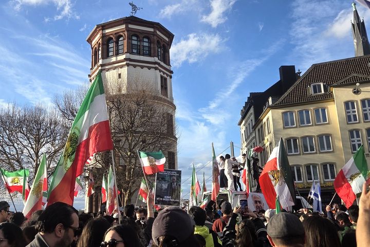 Iran-Demo am Burgplatz: Fahnen vor dem Schlossturm Menschenmenge mit iranischen Fahnen am Burgplatz in Düsseldorf vor dem Schlossturm.