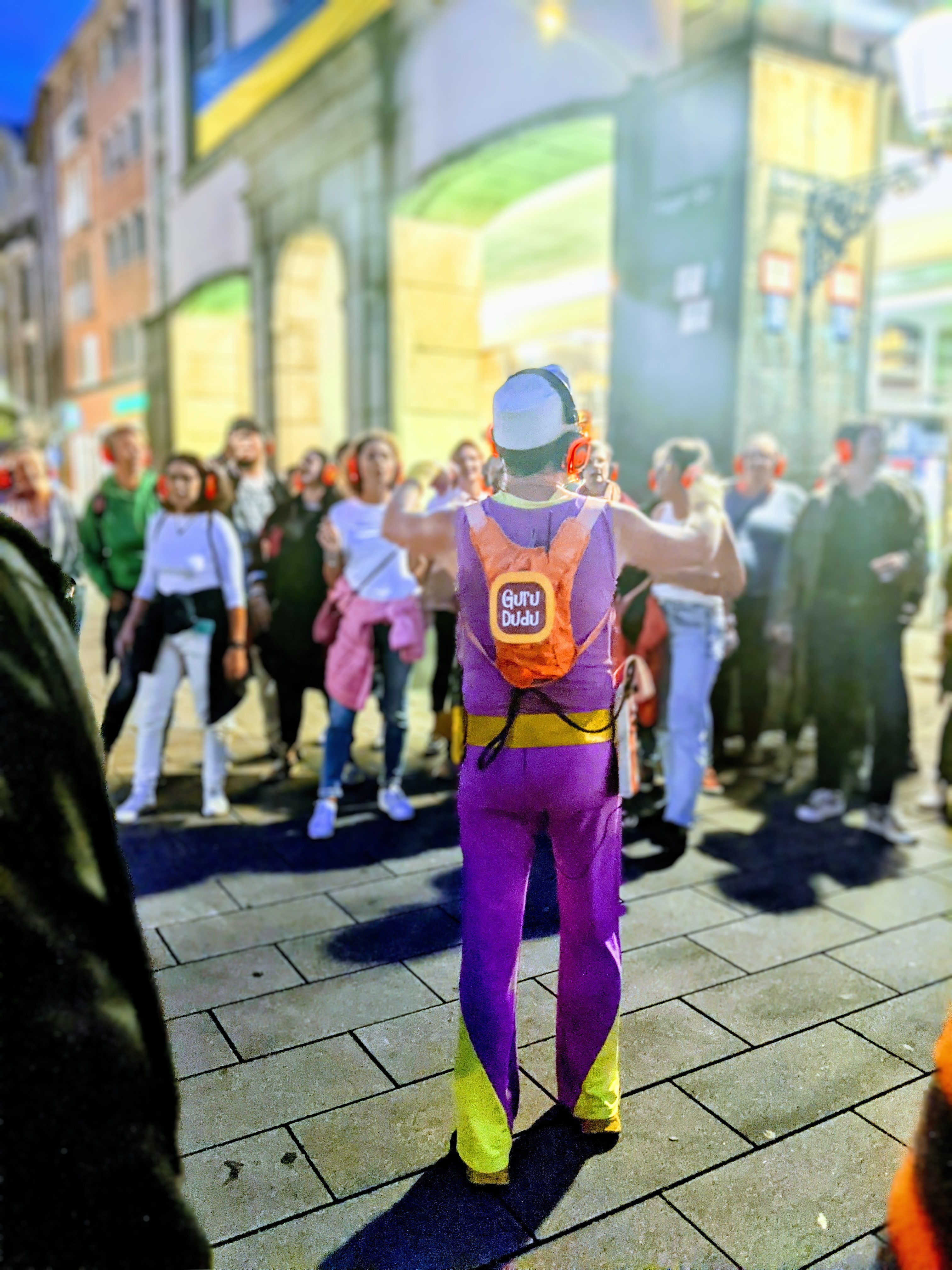 Guru Dudu führt eine Silent Disco Walking Tour mit roten Kopfhörern durch Düsseldorf