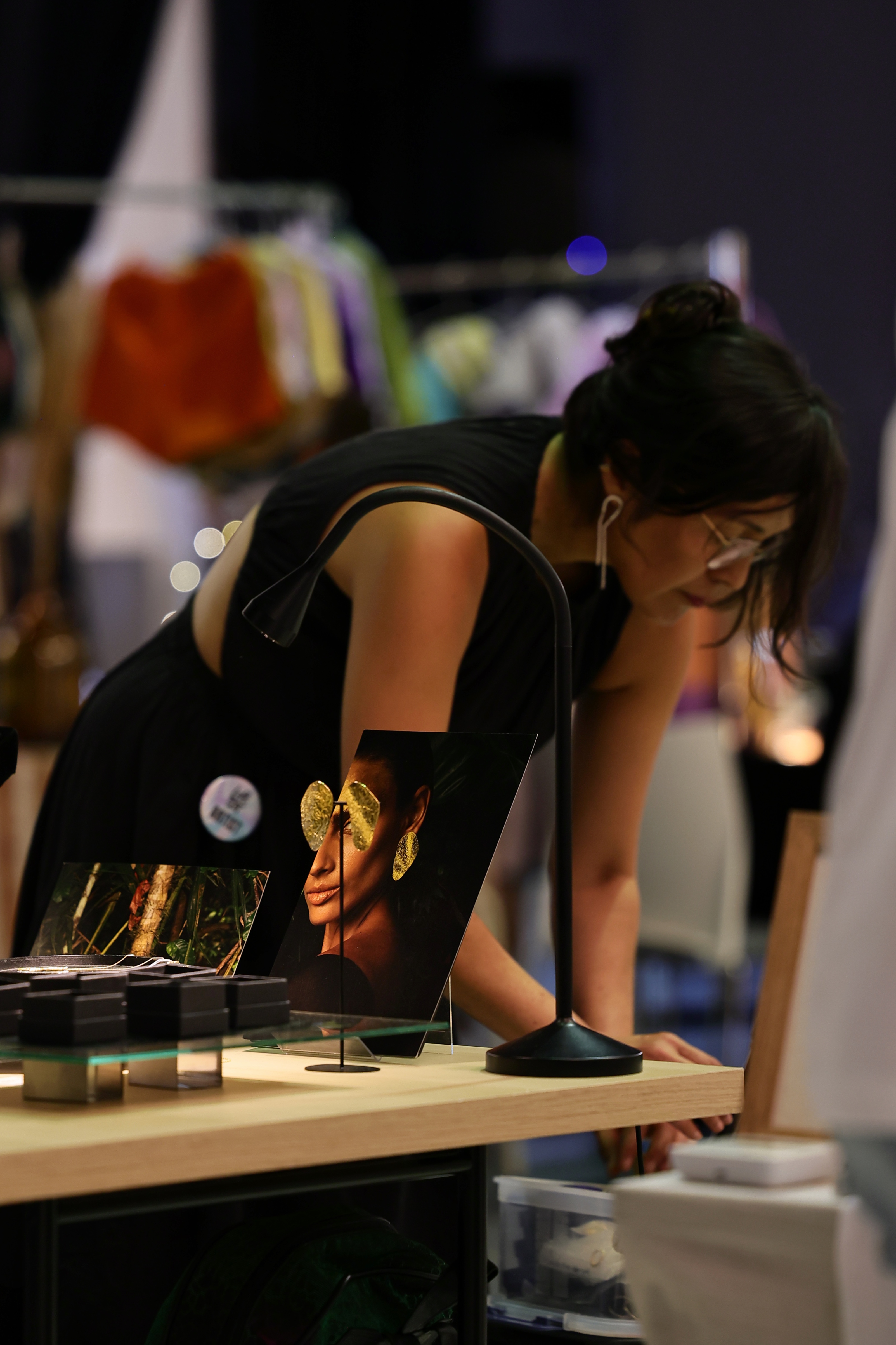 Besucherin betrachtet eine Fotoarbeit an einem Schmuckstand beim Loft of Art #5 PINK in Düsseldorf-Lierenfeld