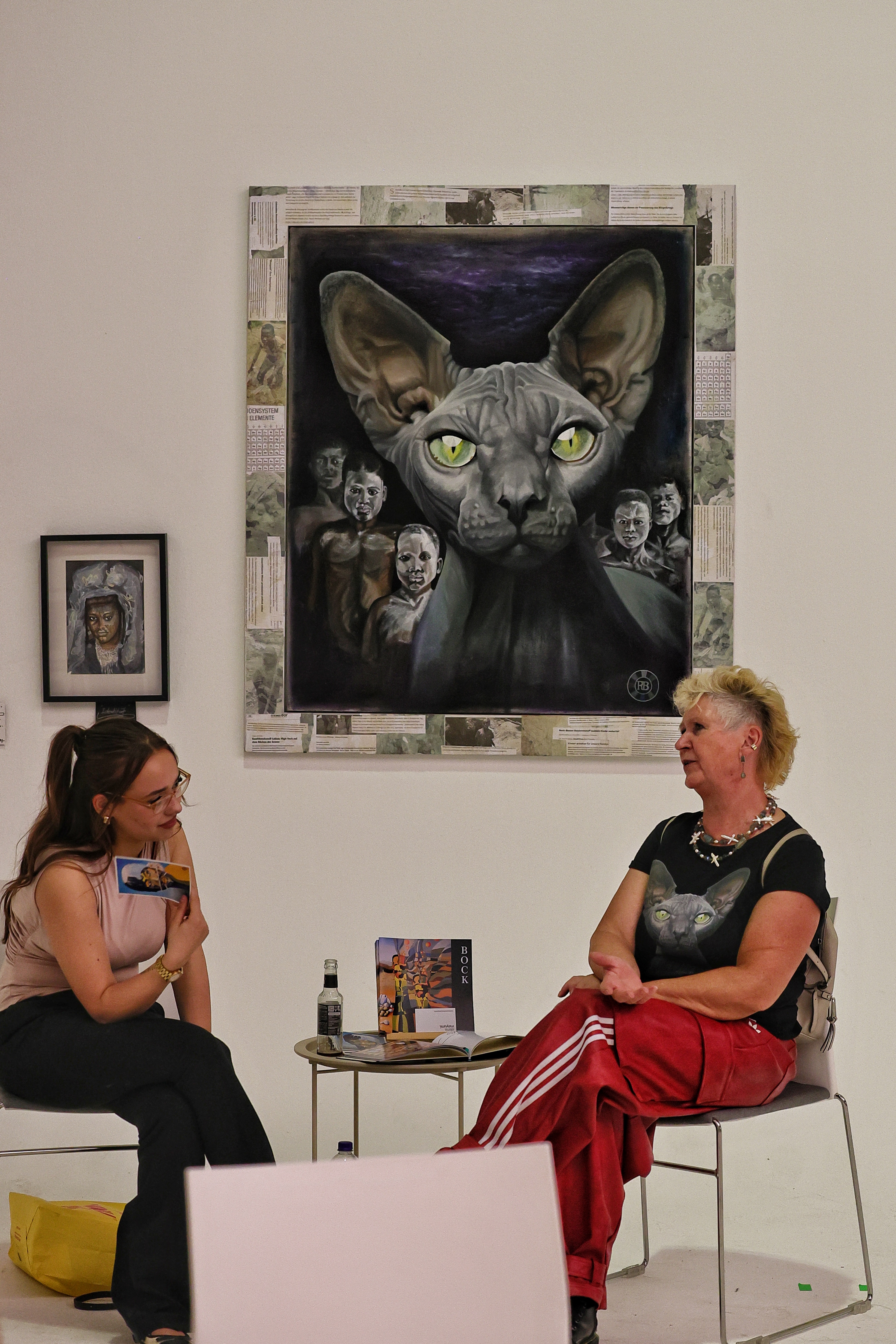 Zwei Frauen im Gespräch unter einem Sphynx-Katzen-Gemälde beim Loft of Art #5 PINK in Düsseldorf-Lierenfeld