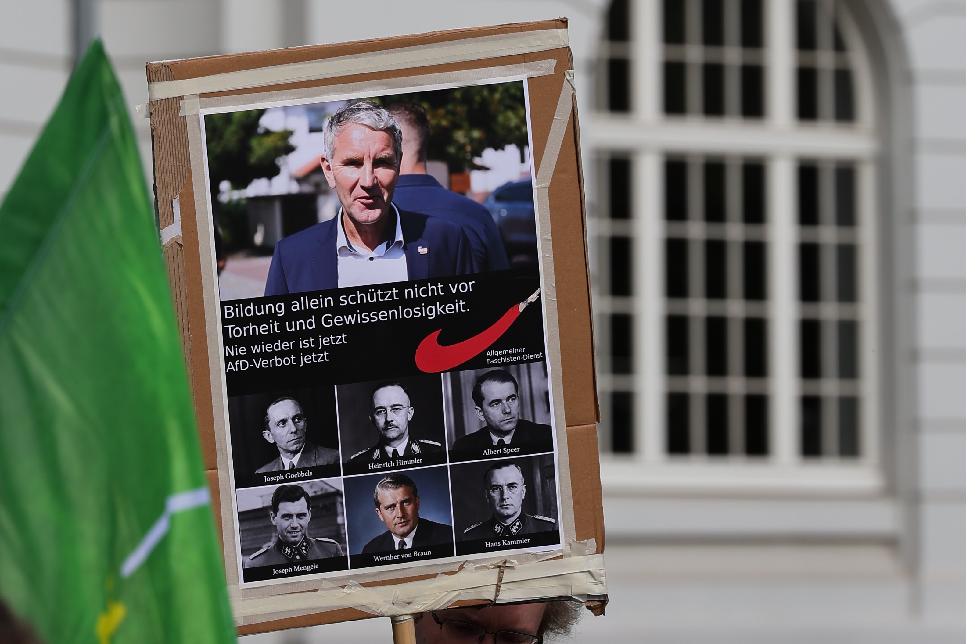 Politisches Plakat mit mehreren Porträtfotos bei der PRÜF-Demonstration
