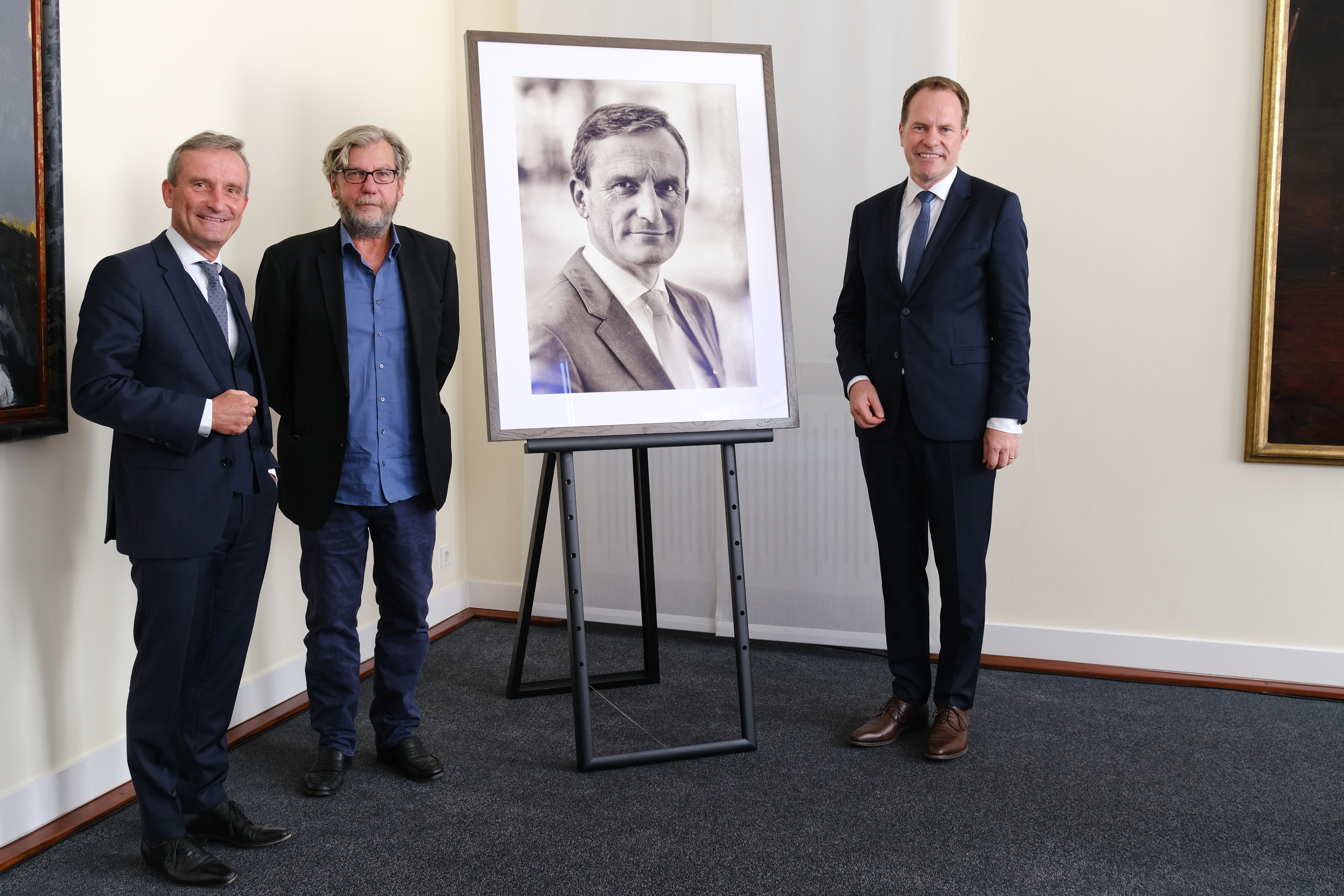 Das vom Fotokünstler Thomas Ruff (Mitte) bearbeitet Porträt von Oberbürgermeister a.D. Thomas Geisel (links) ist die erste Fotografie im Ältestensaal,©Landeshauptstadt Düsseldorf/Michael Gstettenbauer