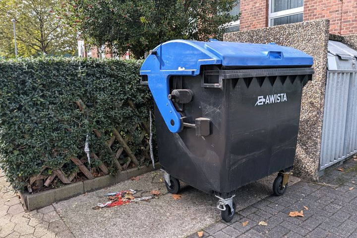 Große schwarze Papiertonne mit blauem Deckel und AWISTA-Logo vor einem Wohnhaus in Düsseldorf-Flingern
