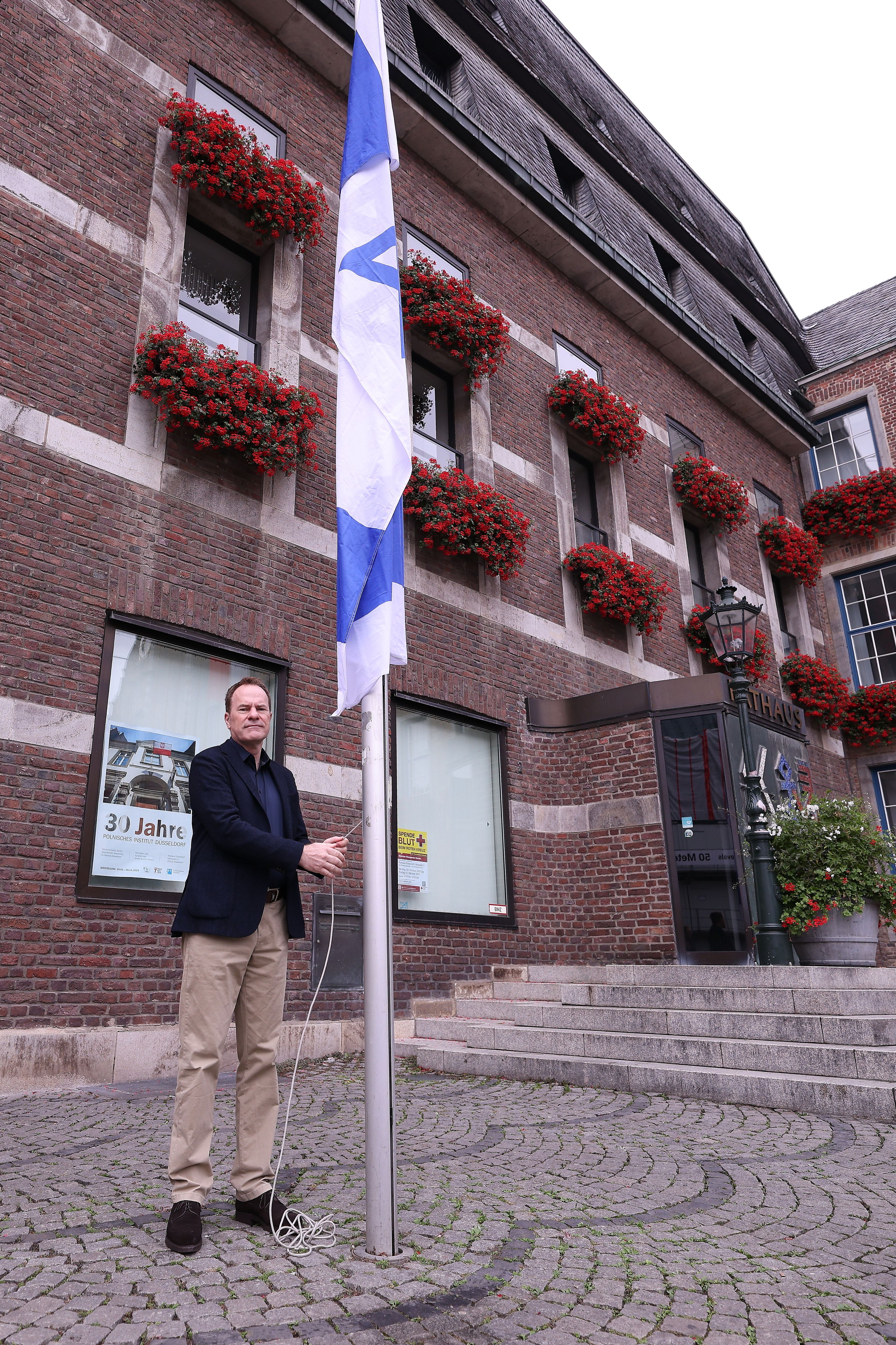Oberbürgermeister Dr. Stephan Keller hisst die israelische Flagge vor dem Rathaus als Zeichen der Solidarität der Landeshauptstadt Düsseldorf mit Israel nach dem Angriff der islamistischen Hamas, Foto © David Young.