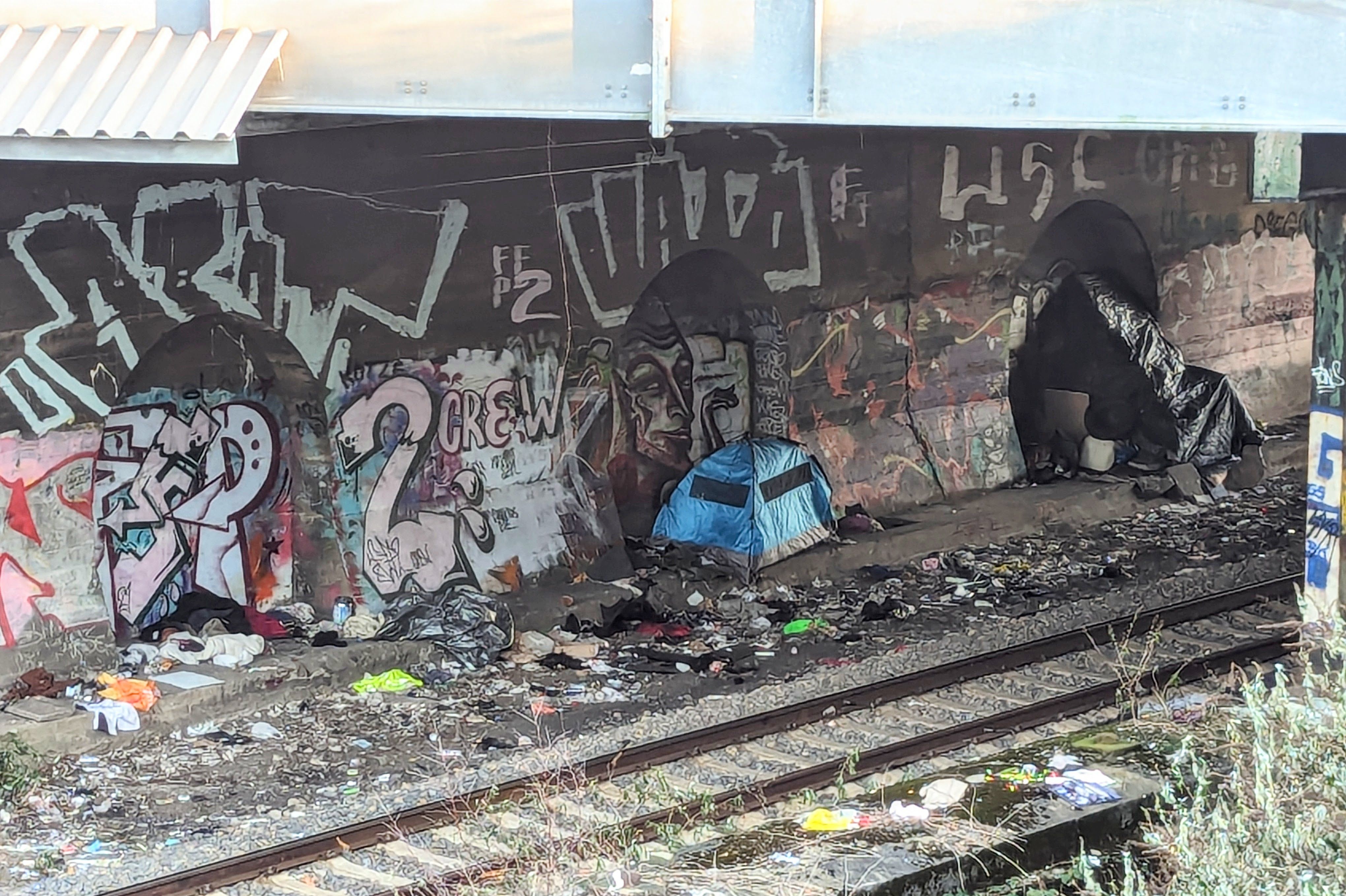 Aufnahme vom Januar 2024 unter der Brücke an der Moskauer Straße: Provisorische Schlafplätze, Zeltplanen und Müll direkt an den Gleisen – eine gefährliche Situation für die Menschen vor Ort und für den Bahnverkehr. / Foto: Alexandra Scholz-Marcovich, NDOZ