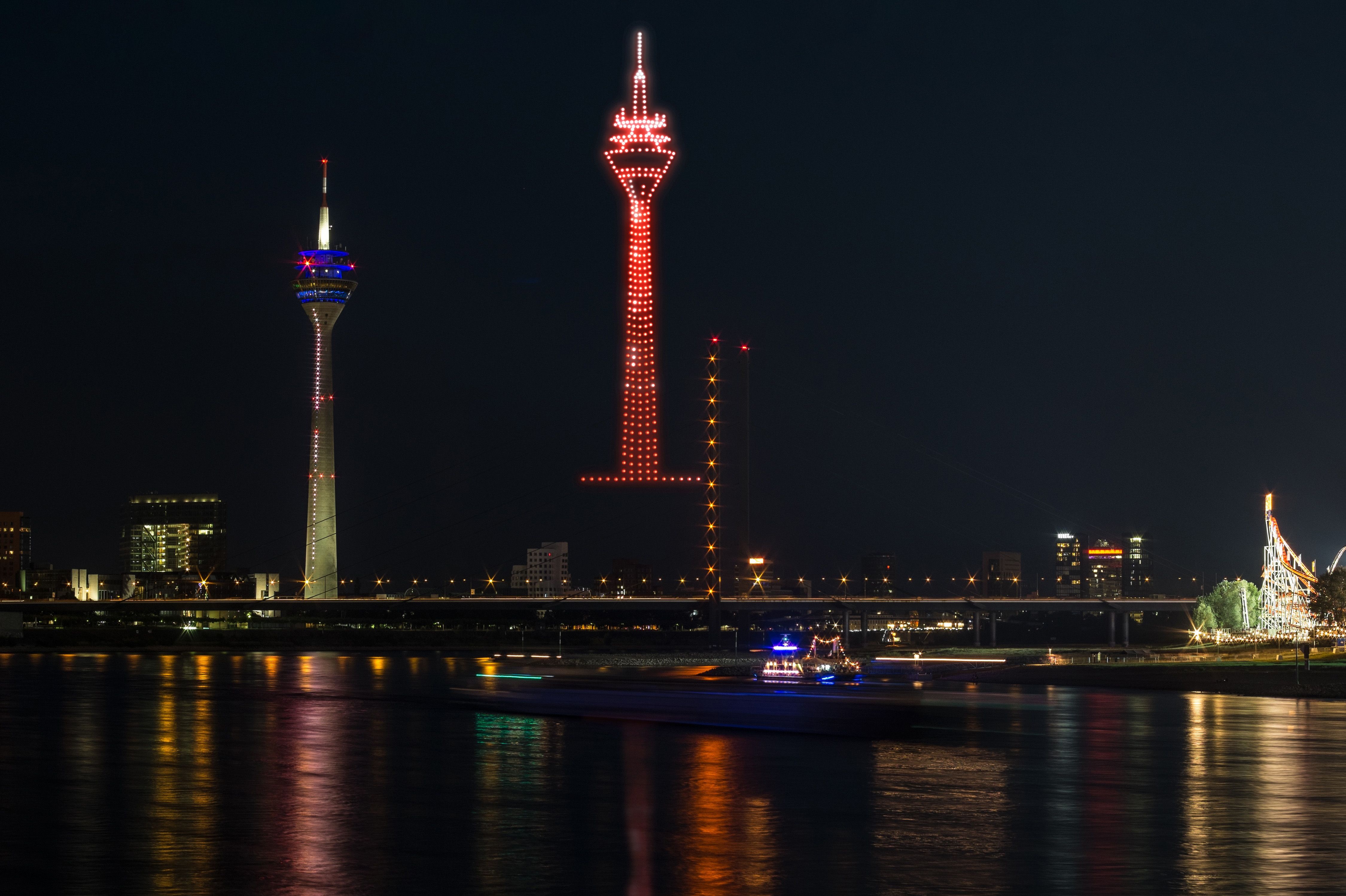 Digitaler Rheinturm: Bei der AO-Drohnenshow zur Rheinkirmes erscheint das Wahrzeichen der Stadt als leuchtende Kopie am Himmel – direkt neben dem Original. / Foto: AO Multimedia & Drones 