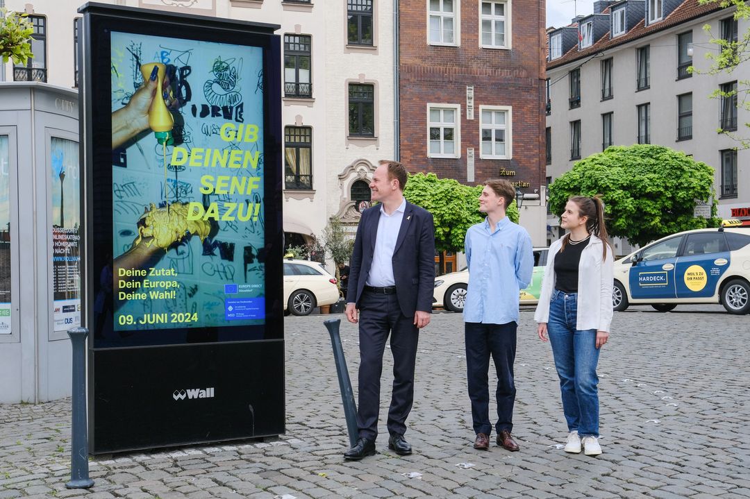   Oberbürgermeister Dr. Stephan Keller präsentiert gemeinsam mit den Designstudierenden der Hochschule Münster Julia Munt und Linus Mütze die Europa-Plakatkampagne © Landeshauptstadt Düsseldorf/Michael Gstettenbauer 