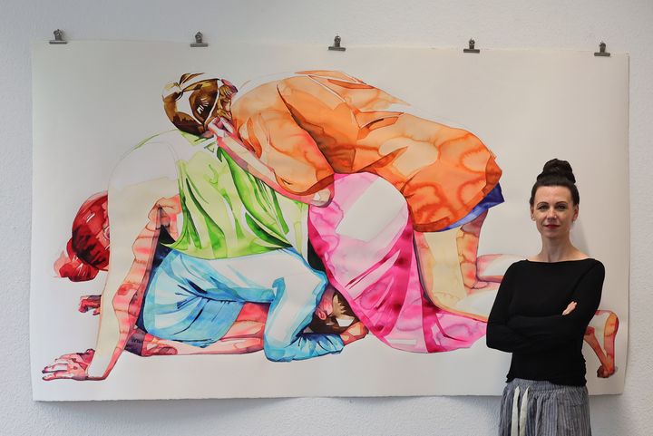 Aline Regese, Malerin und Vorstand des Vereins Düsseldorfer Künstlerinnen (VdK), vor ihren farbintensiven Aquarellen in der Ausstellung „KÜNSTLERINNEN! JETZT!“ in Düsseldorf-Heerdt. / Foto: Klaus von Jackelmann