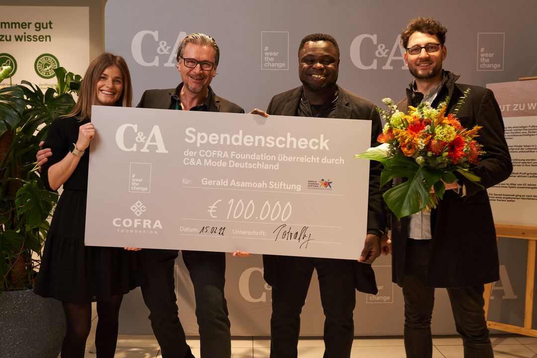 Spendenscheck in Hohe von 100.000 Euro  in Düsseldorfer Filiale an Ex-Fußballnationalspieler Gerald Asamoah übergeben / Von links: Annika Peters (C&A Event Managerin), Christof Potrafky (Store Manager C&A), Gerald Asamoah (Vorstandsvorsitzender Gerald-Asamoah-Stiftung), Jens Conrad (Gerald-Asamoah-Stiftung)©C&A