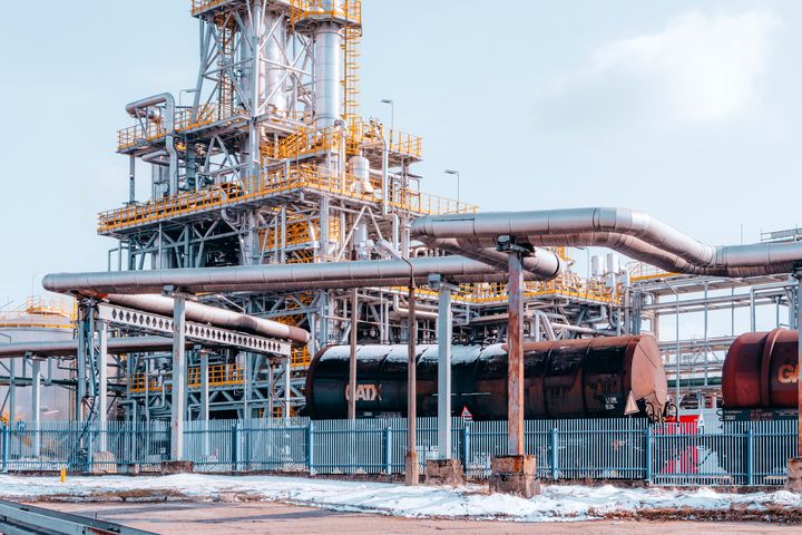 Raffinerie und Ölindustrie Industrieanlage einer Raffinerie mit Rohrleitungen und Kesselwagen im Vordergrund
