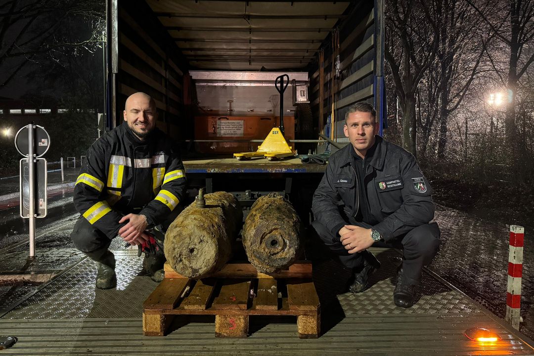 Entschärfer Julian Granzow (r.) vom Kampfmittelbeseitigungsdienst der Bezirksregierung mit seinem Kollegen Adis Kalic und den zwei entschärften Fliegerbomben aus dem Zweiten Weltkrieg. / Foto: Feuerwehr Düsseldorf