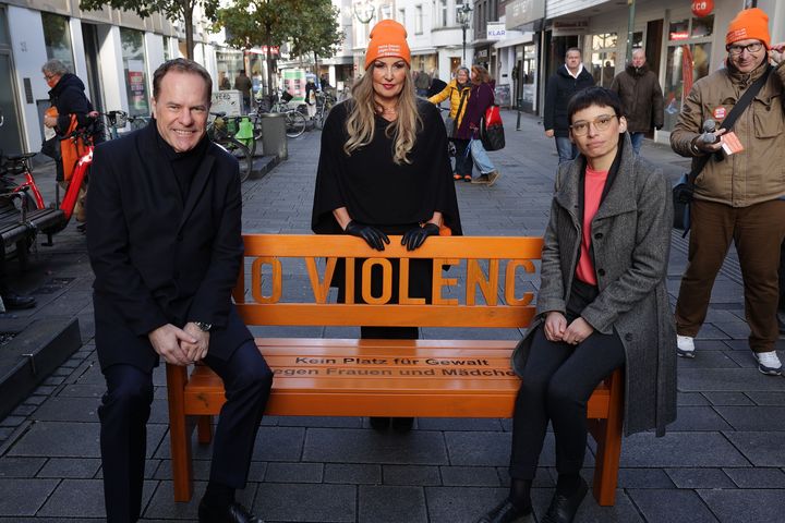 OB Dr. Keller, Elisabeth Wilfart, Leiterin des Amtes für Gleichstellung und Antidiskriminierung, und Ministerin Josefine Paul (v.l.) präsentieren die orangene Bank mit dem Schriftzug "No Violence - Kein Platz für Gewalt gegen Frauen und Mädchen (c)Landeshauptstadt Düsseldorf/David Young