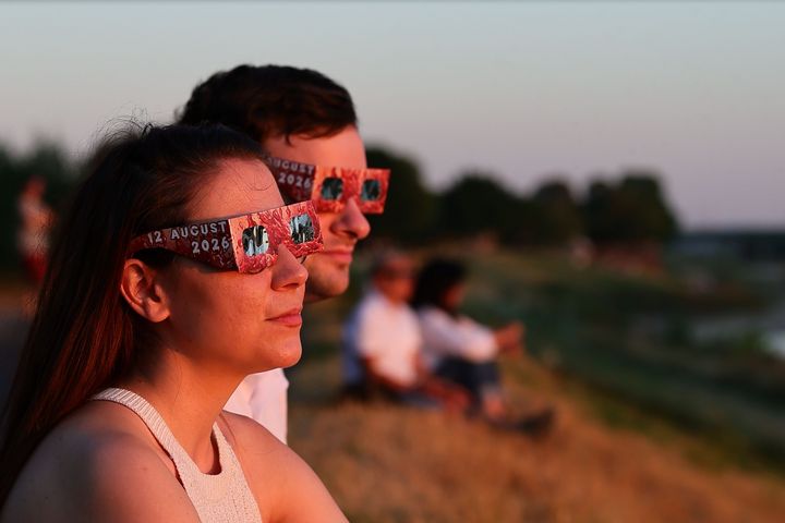 Ein Paar beobachtet die Sonnenfinsternis mit speziellen Schutzbrillen am Düsseldorfer Rheinufer.