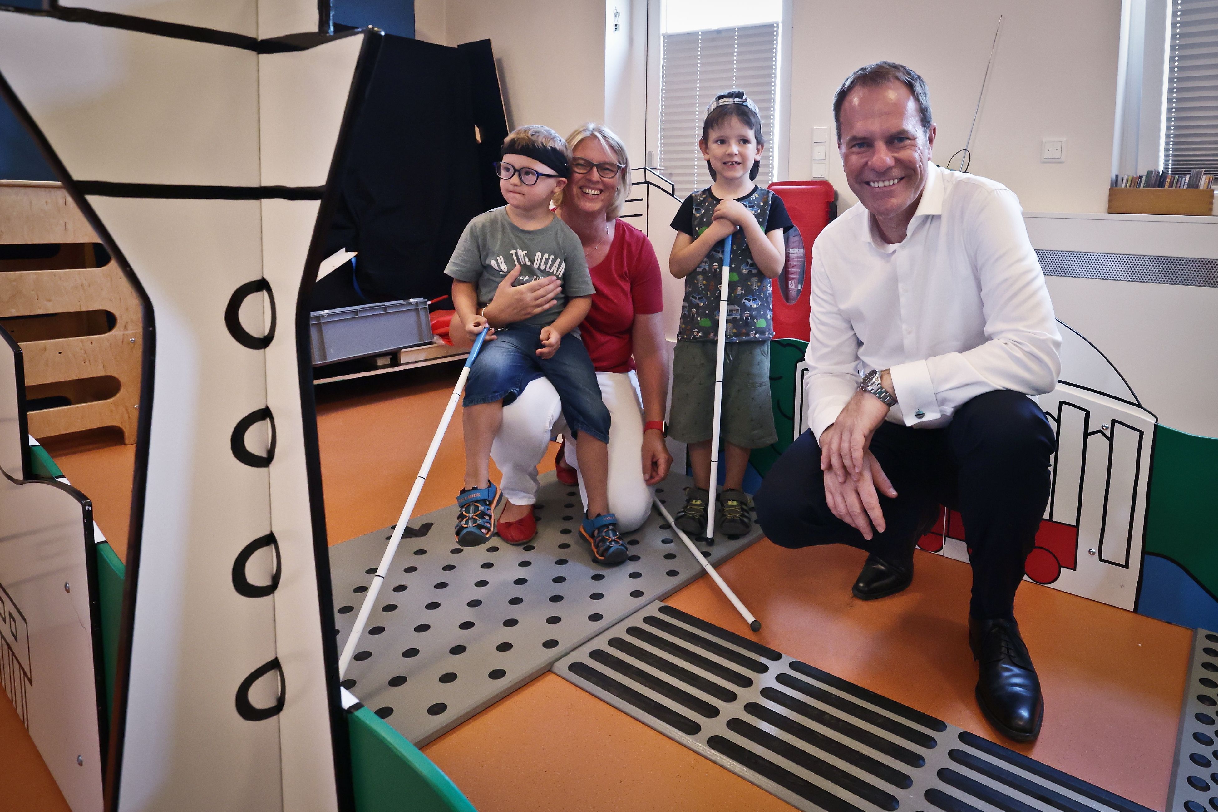 Oberbürgermeister Dr. Stephan Keller und Kita-Leiterin Nicole Zucali verschafften sich einen Eindruck vom Parcours mit Düsseldorfer Motiven, der eine spielerische Herangehensweise an das Thema Sehbehinderung und Blindenleitsystem ermöglicht © Landeshauptstadt Düsseldorf/David Young