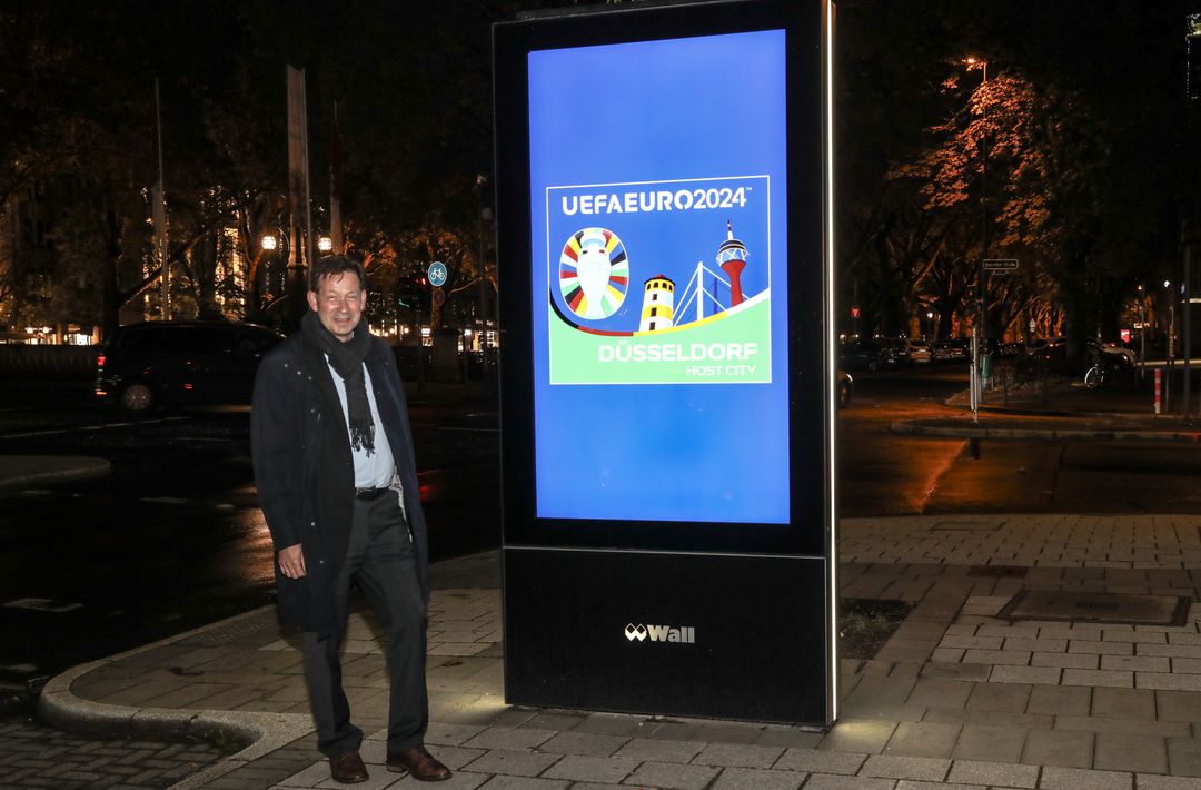 Stadtdirektor Burkhard Hintzsche an einem der 44 digitalen Werbeträger mit dem UEFA Euro2024 Düsseldorf-Logo © Melanie Zanin/Landeshauptstadt Düsseldorf 