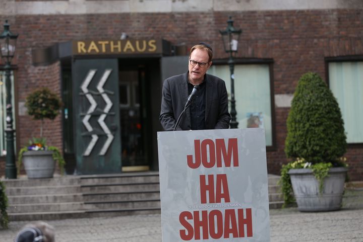 Oberbürgermeister Dr. Stephan Keller spricht am Podium mit der Aufschrift „Jom Ha Shoah" vor dem Düsseldorfer Rathaus.