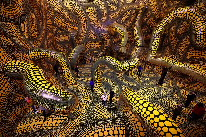 Besucher im Infinity Mirrored Room von Yayoi Kusama, Museum Ludwig Köln 2026 — gelb-schwarze Punktmuster überziehen Wände, Boden und Decke