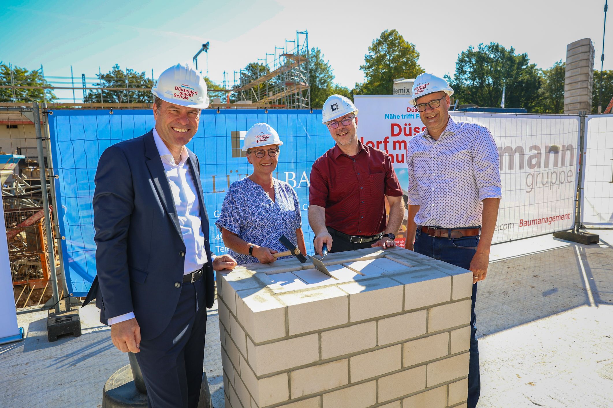 Oberbürgermeister Dr. Stephan Keller (v.l.n.r.), Amtsleiterin Dagmar Wandt, Schulleiter Jörg Napiwotzki und Ratsherr Dr. Thorsten Graeßner legen den Grundstein für den Neubau der Theodor-Litt-Realschule © Landeshauptstadt Düsseldorf/Melanie Zanin 