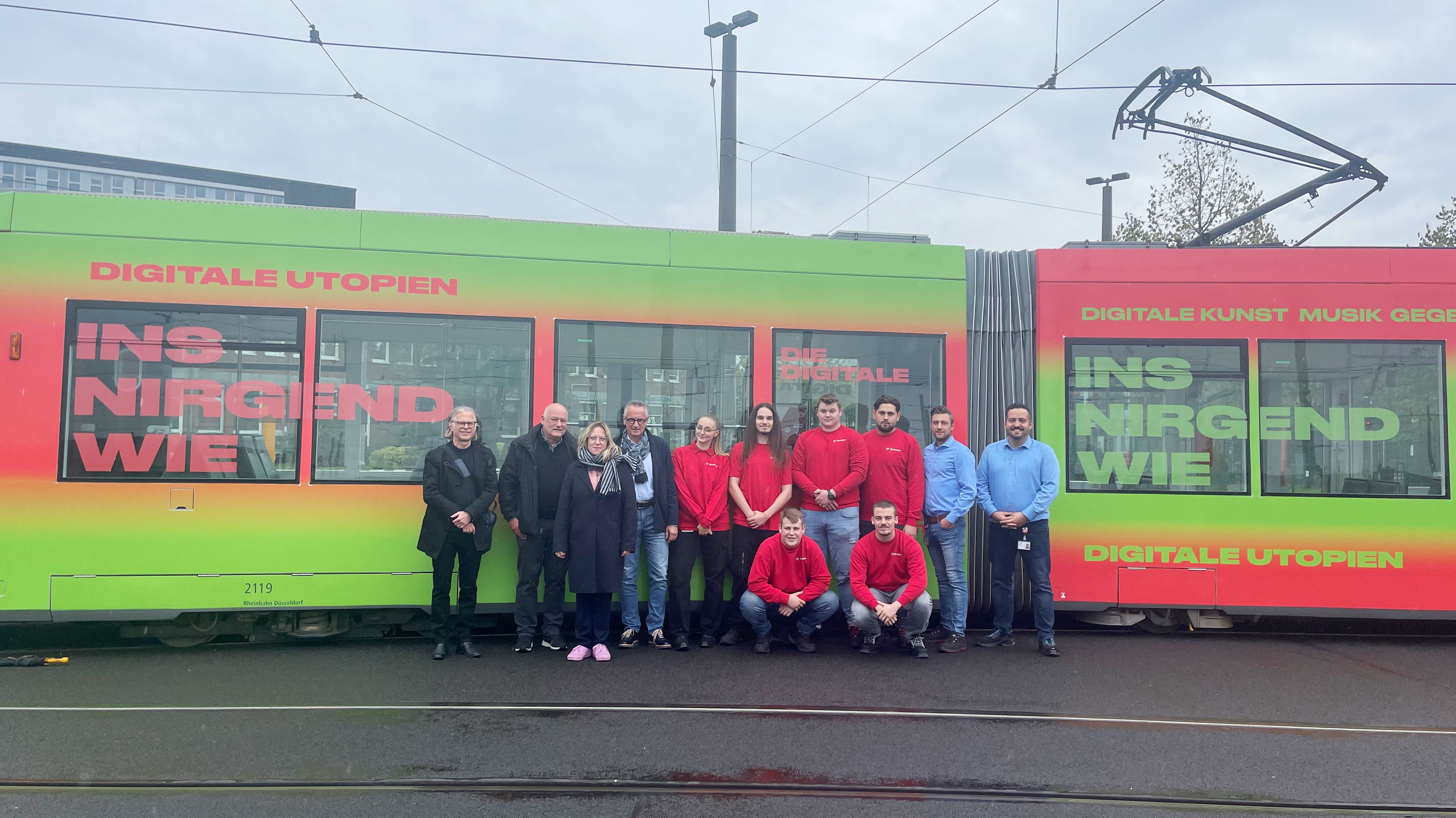 Freuen sich über die gelungene Gestaltung der Bahn: Die Künstler Peter Michael Witt und Werner Pillig, Katharina Drasdo (Kommunikationsdesignerin), Klaus Klar (Vorstandsvorsitzender und Arbeitsdirektor der Rheinbahn) und die Auszubildenden und Ausbilder, die die Bahn beklebt haben (von links) / Foto © Rheinbahn