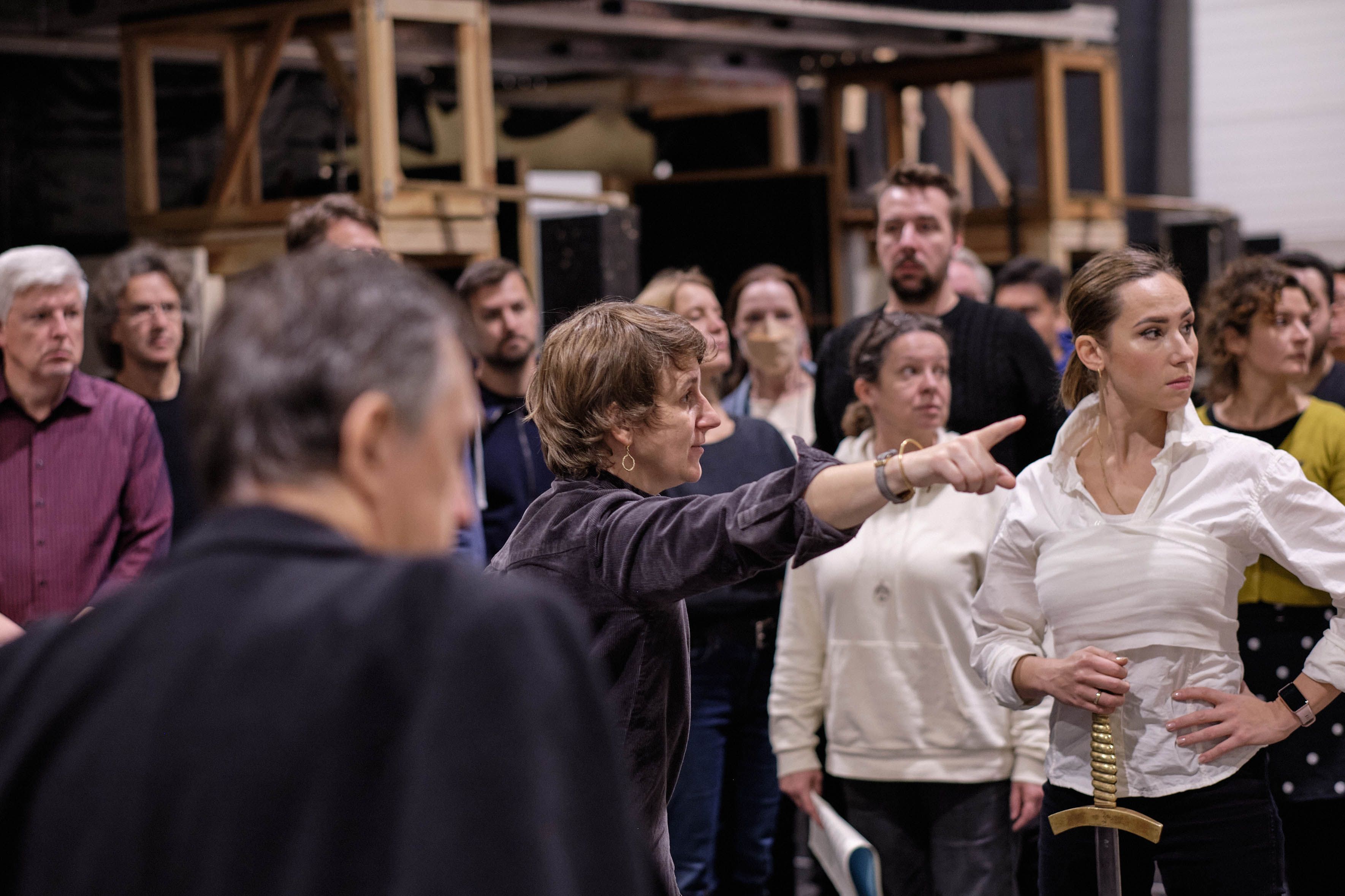 Vorne: Sergej Khomov (König Karl VIII.), Mitte: Elisabeth Stöppler (Inszenierung), Maria Kataeva (Johanna von Orléans), dahinter: Chor der Deutschen Oper am Rhein/ Foto © Daniel Senzek