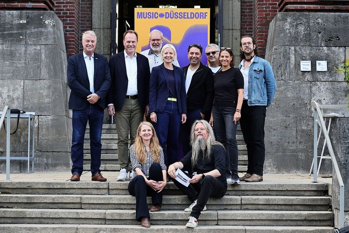 Gruppenfoto vor dem NRW-Forum: Ulf Montanus (OB-Kandidat FDP), Dr. Stephan Keller (OB-Kandidat CDU), Markus Raub (Vertretung für SPD-Kandidat Fabian Zachel), Clara Gerlach (OB-Kandidatin Bündnis 90/Die Grünen), Hamed Shahi (Vorstand Music Düsseldorf), Prof. Dr. Carsten Winter, Daniela Stork und Felix Wursthorn (Vorstand Music Düsseldorf) – vorne Melanie Schrader (Vorstand Music Düsseldorf) und Carsten Schumacher (Moderator des Abends). / Foto: Klaus von Jackelmann