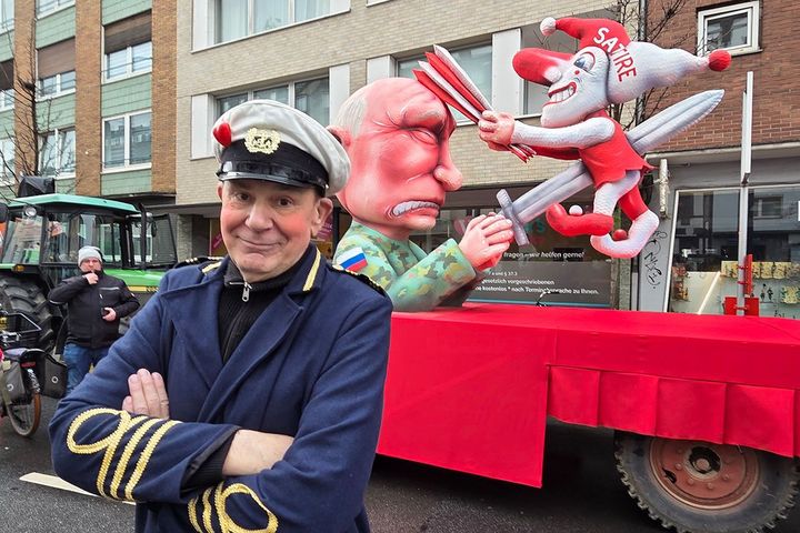 Jacques Tilly steht beim Rosenmontagszug 2026 in Düsseldorf vor dem Mottowagen „Putin vs. Narr (Satire)“