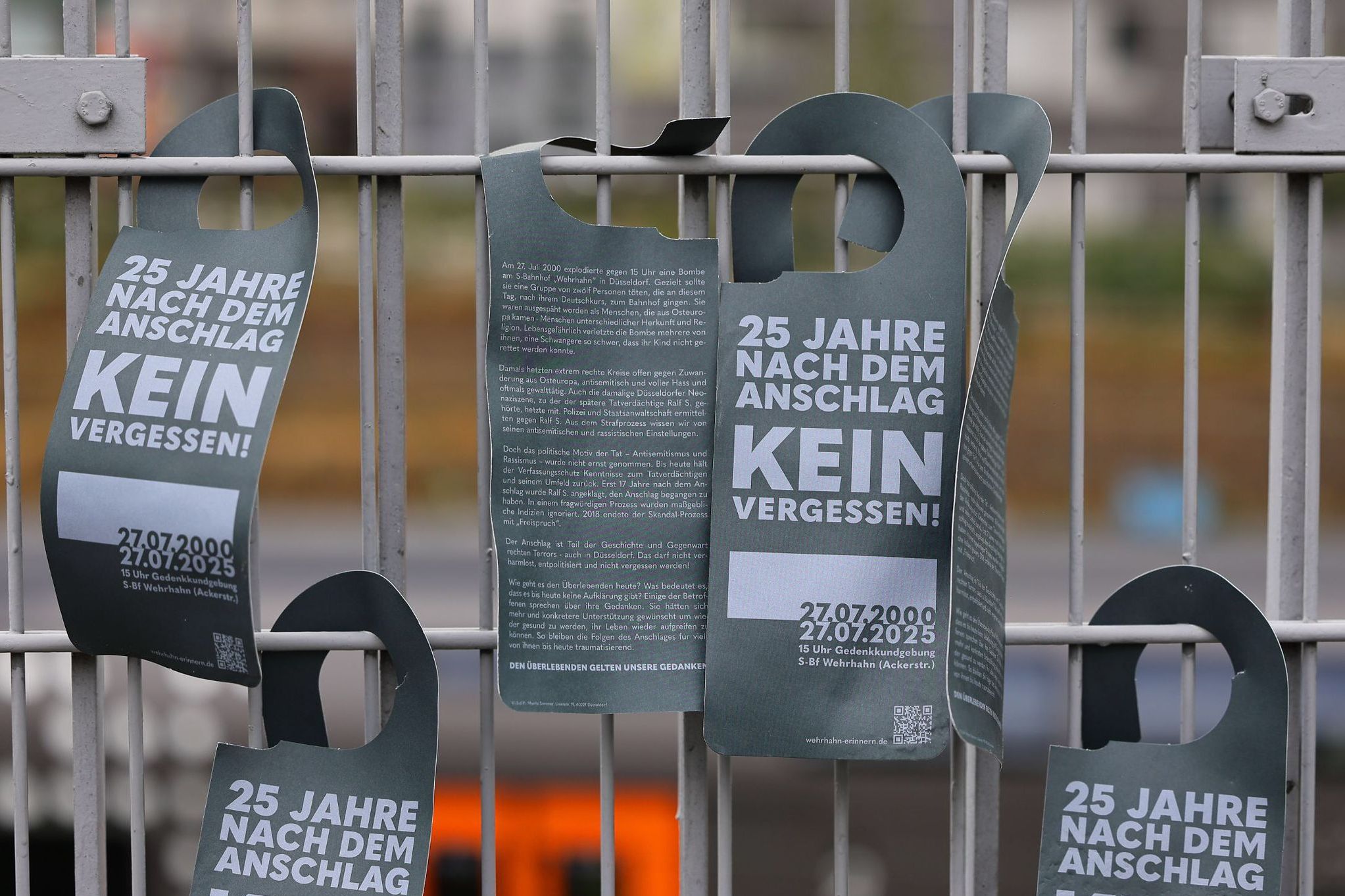 „25 Jahre nach dem Anschlag – Kein Vergessen“: Am Zaun der S-Bahnstation erinnerten Türhänger mit Botschaften an die Tat vom 27. Juli 2000 und forderten gesellschaftliches Gedenken. / Foto: Klaus von Jackelmann