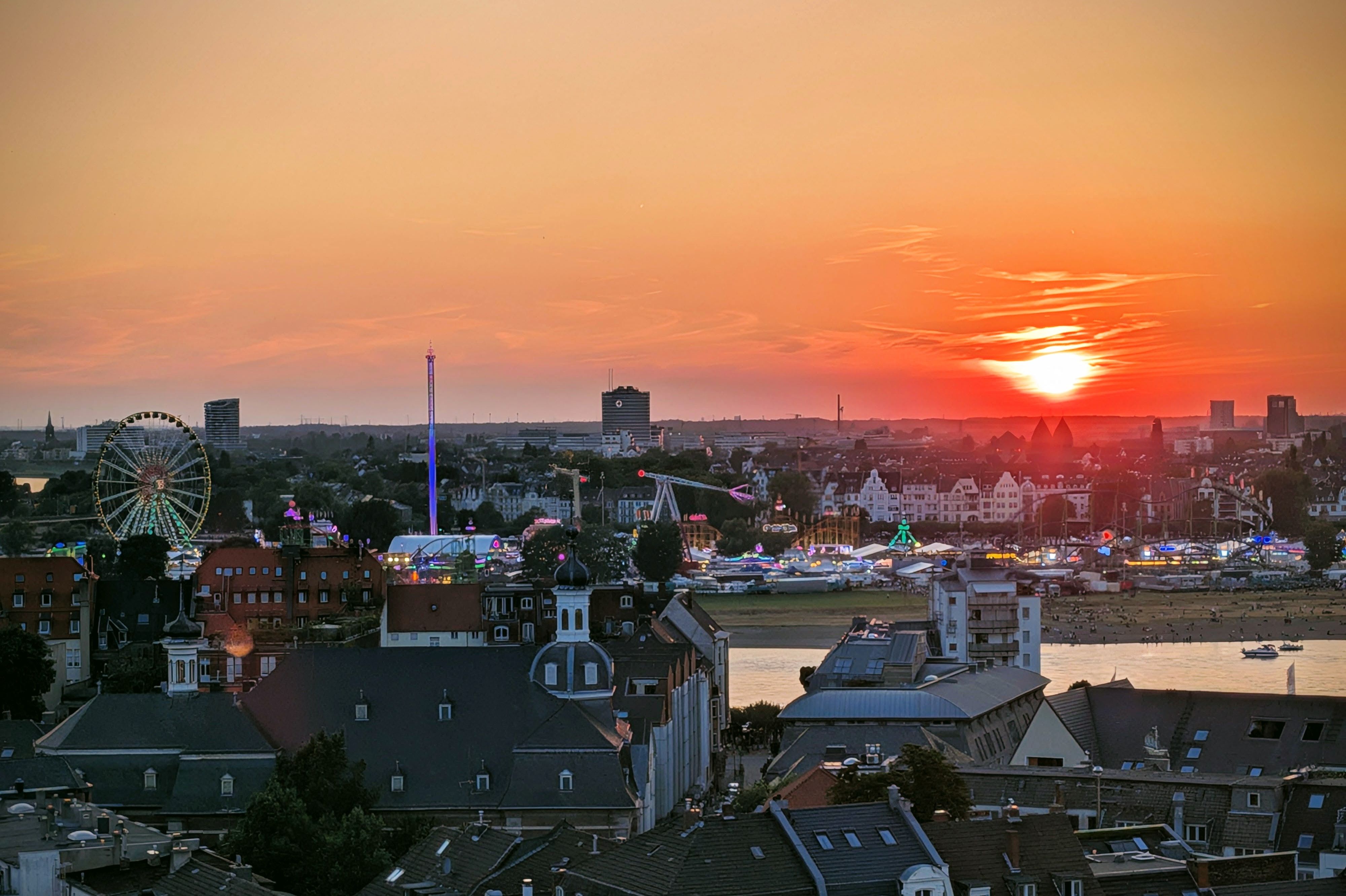 Zwischen Licht und Rummel: Die Sonne sinkt über der Rheinkirmes – goldenes Zwischenspiel mitten im Abend. / Foto: Stefan Scholz, NDOZ