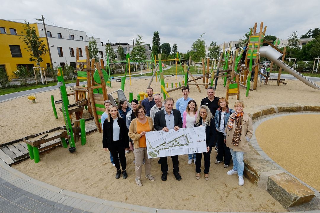 Eröffnung des neuen Spielplatzes in Gerresheim mit Spielplatzpatinnen und paten, Anwohnenden, Bezirksbürgermeisterin Maria Icking (vorne 1. v.l.), Beigeordneten Jochen Kral (vorne 2.v.l.) und Henrike Mölleken vom Gartenamt (vorne 3. v.l.) ) und Landschaftsarchitektin Henrike Scriverius (vorne 4. v.l.). Im Zentrum der Wohnbausiedlung zwischen Cottbusser Straße, Pirnaer Straße und Zittauer Straße ist ein 3.800 Quadratmeter großer Park mit vielfältigem Spielangebot entstanden. / Foto: Landeshauptstadt Düsseldorf/Wilfried Meyer