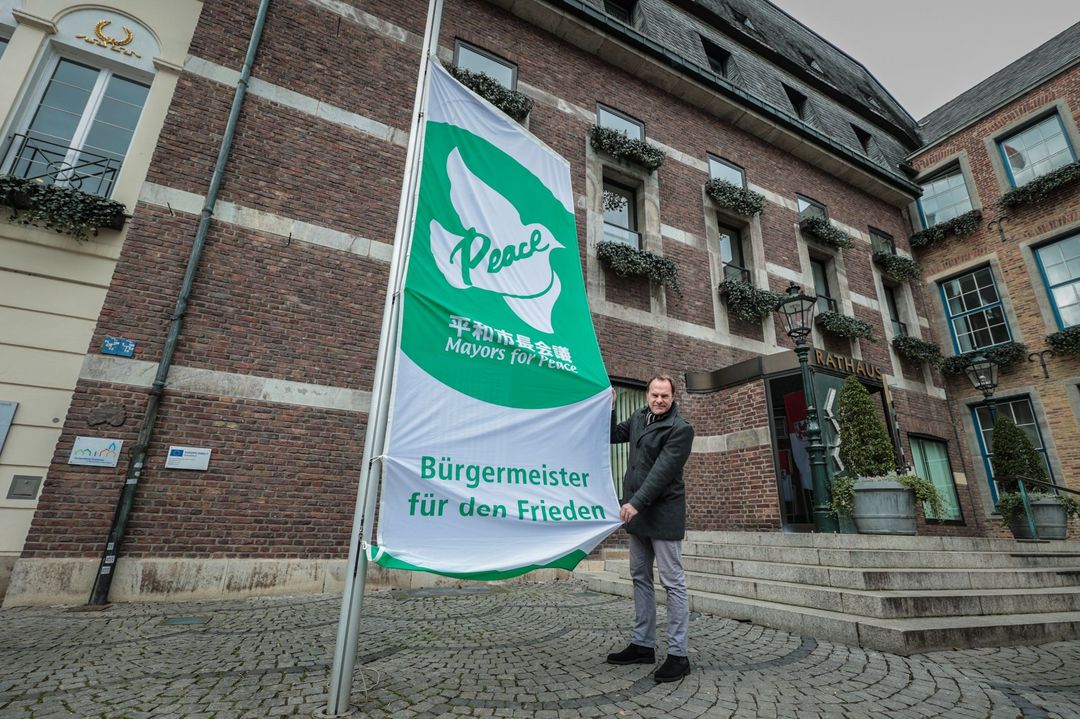 Als Zeichen der Solidarität mit den Urkrainerinnen und Ukrainern hat Oberbürgermeister Dr. Stephan Keller die "Mayors For Peace"-Fahne vor dem Rathaus gehisst © Landeshauptstadt Düsseldorf/Melanie Zanin 