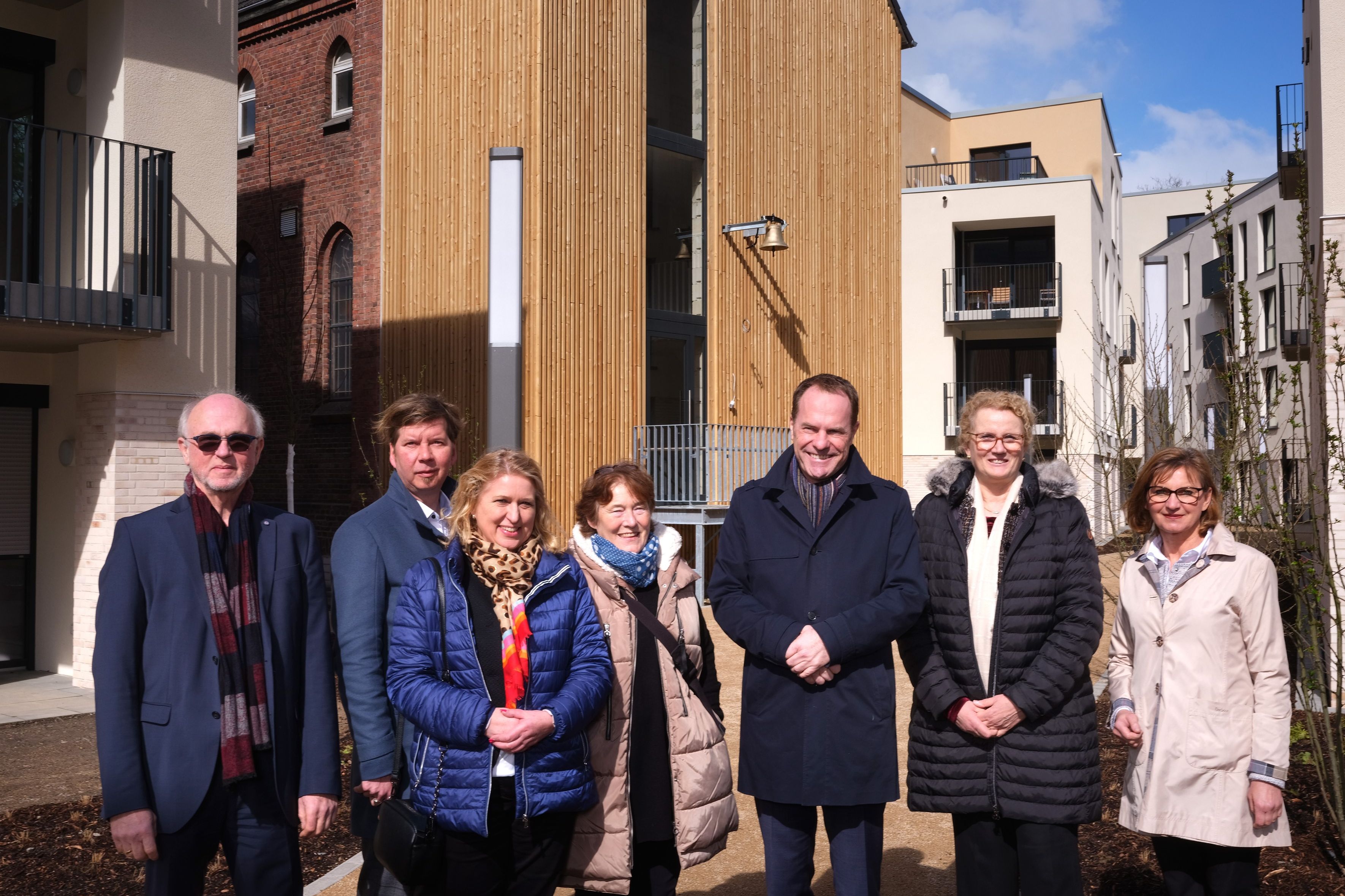 Hospitalstraße Gruppenbild vor alter Kapelle: von links nach rechts: Dr. Alexander Fils (Vorsitzender des Ausschusses für Planung und Stadtentwicklung),  Klaus Feldhaus (Geschäftsführer SWD), Angelika Penack-Bielor (stellv. Aufsichtsratsvorsitzende SWD), Brigitte Krall („Gemeinsam Leben am Schloss Benrath e.V.“), Dr. Stephan Keller (Oberbürgermeister der Landeshauptstadt Düsseldorf), Marion Warden (Kreisgeschäftsführerin Arbeiterwohlfahrt Düsseldorf) und Dr. Eva-Maria Illigen-Günther (Geschäftsführerin SWD) / Foto © SWD Düsseldorf, Fotograf Bernd Schaller