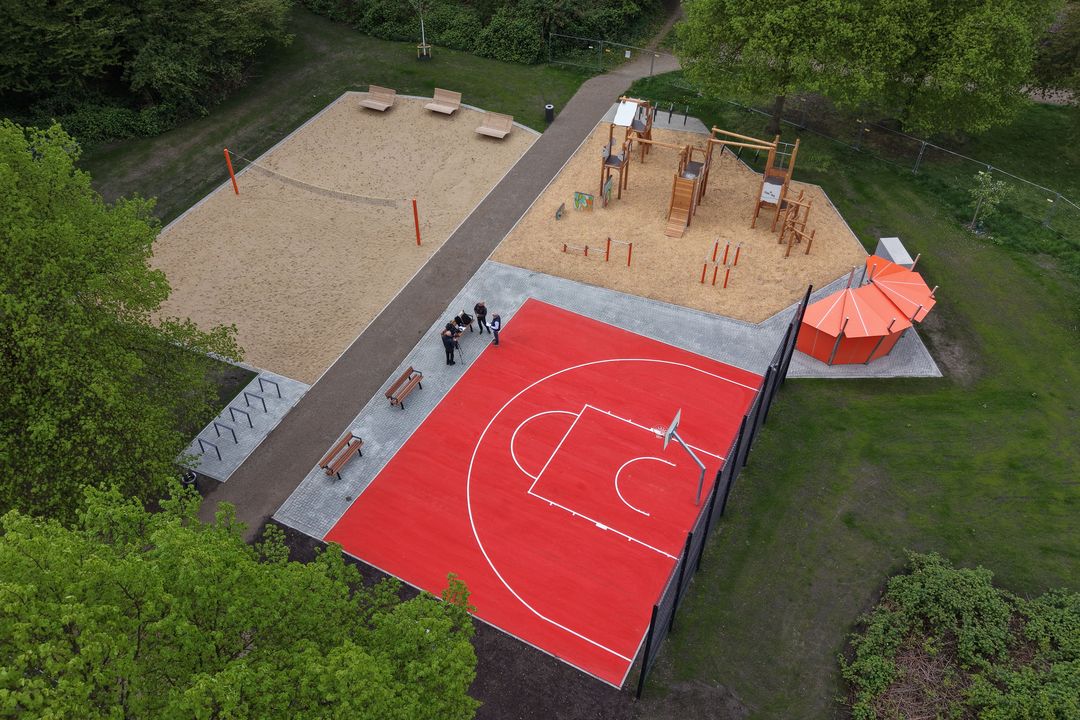 Luftaufnahme der neuen multifunktionalen Sportanlage an der Diepenstraße in Düsseldorf-Gerresheim mit rotem Basketballfeld, Ninja-Parcours und Beachvolleyballfeld