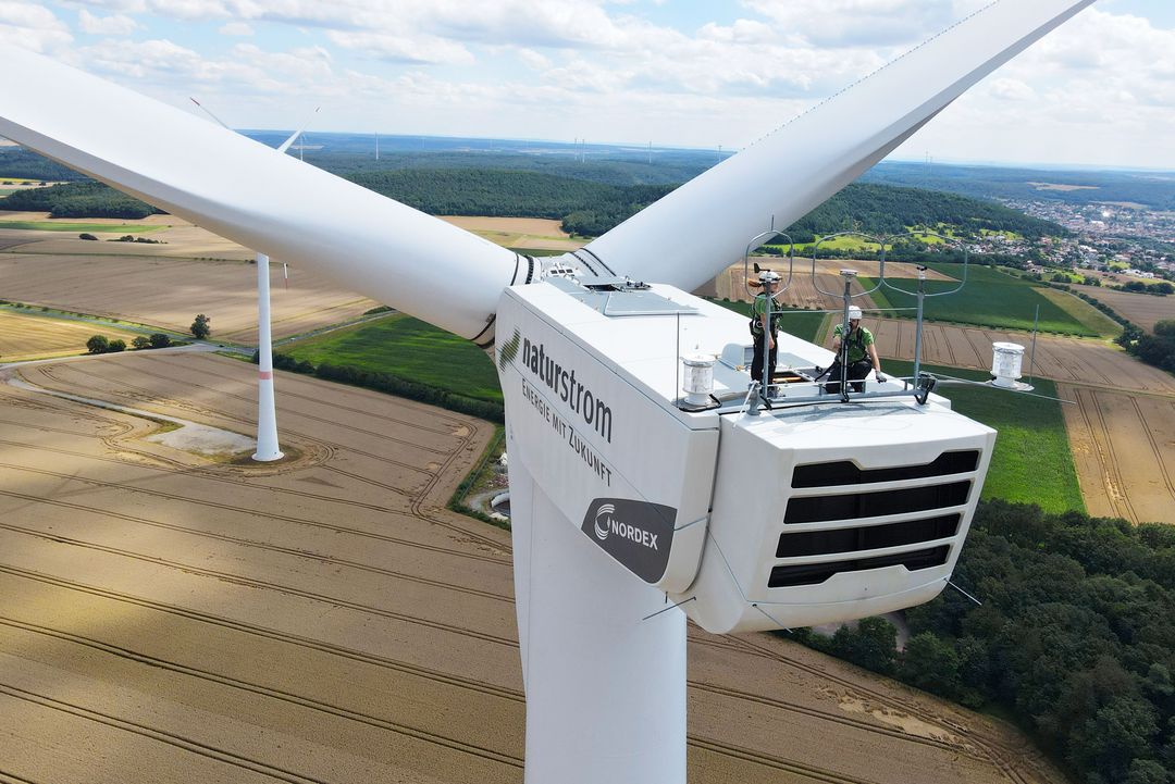 Rekordumsätze und CO2-Einsparungen unterstreichen das Engagement des Unternehmens / Foto: naturstrom AG, Mitarbeiter auf Windrad
