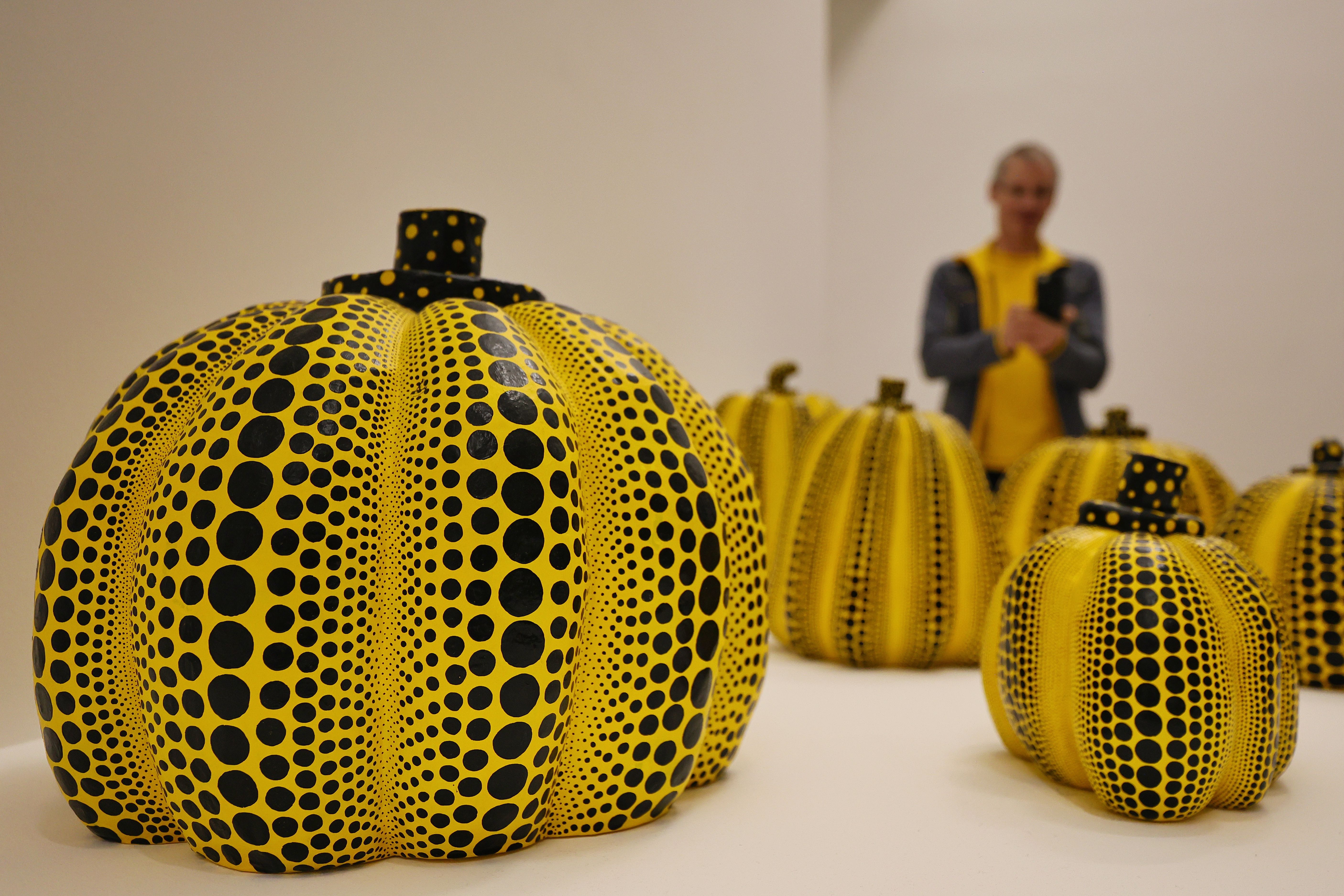 Gelb-schwarz gepunktete Kürbisskulpturen von Yayoi Kusama im Museum Ludwig Köln, Besucher im Hintergrund