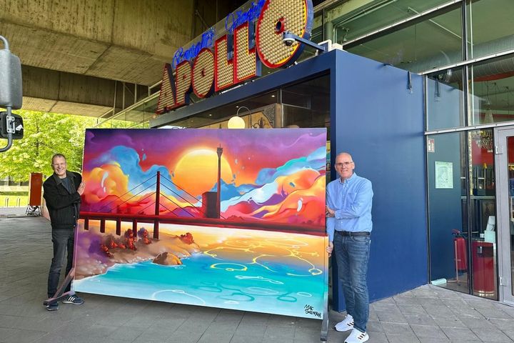 Hubert Ostendorf (links), Geschäftsführer von fiftyfifty, und Carsten Colter (rechts), Geschäftsführer von Colter Fenster Türen Glas GmbH, präsentieren das Street-Art-Kunstwerk von Mac Sullivan vor dem Apollo Varieté. / Foto: fifty fifty