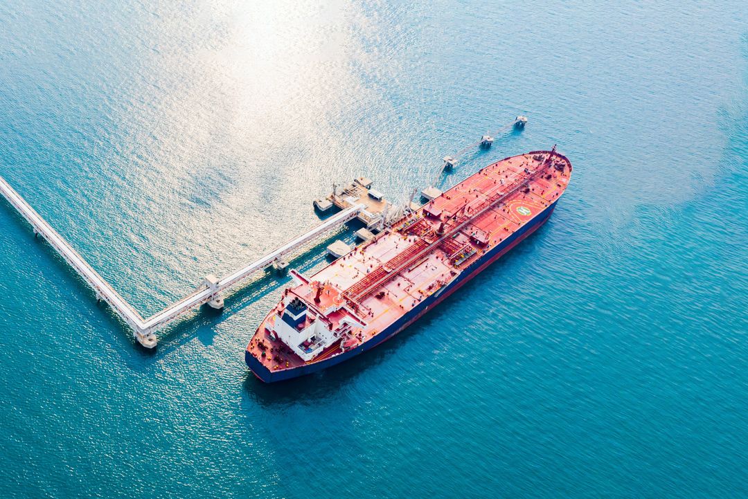 Luftaufnahme eines modernen Seehafens mit Verladeanlagen für Öltanker und Offshore-Plattformen – Symbol für globale Energieversorgung und Rohstoffmärkte.