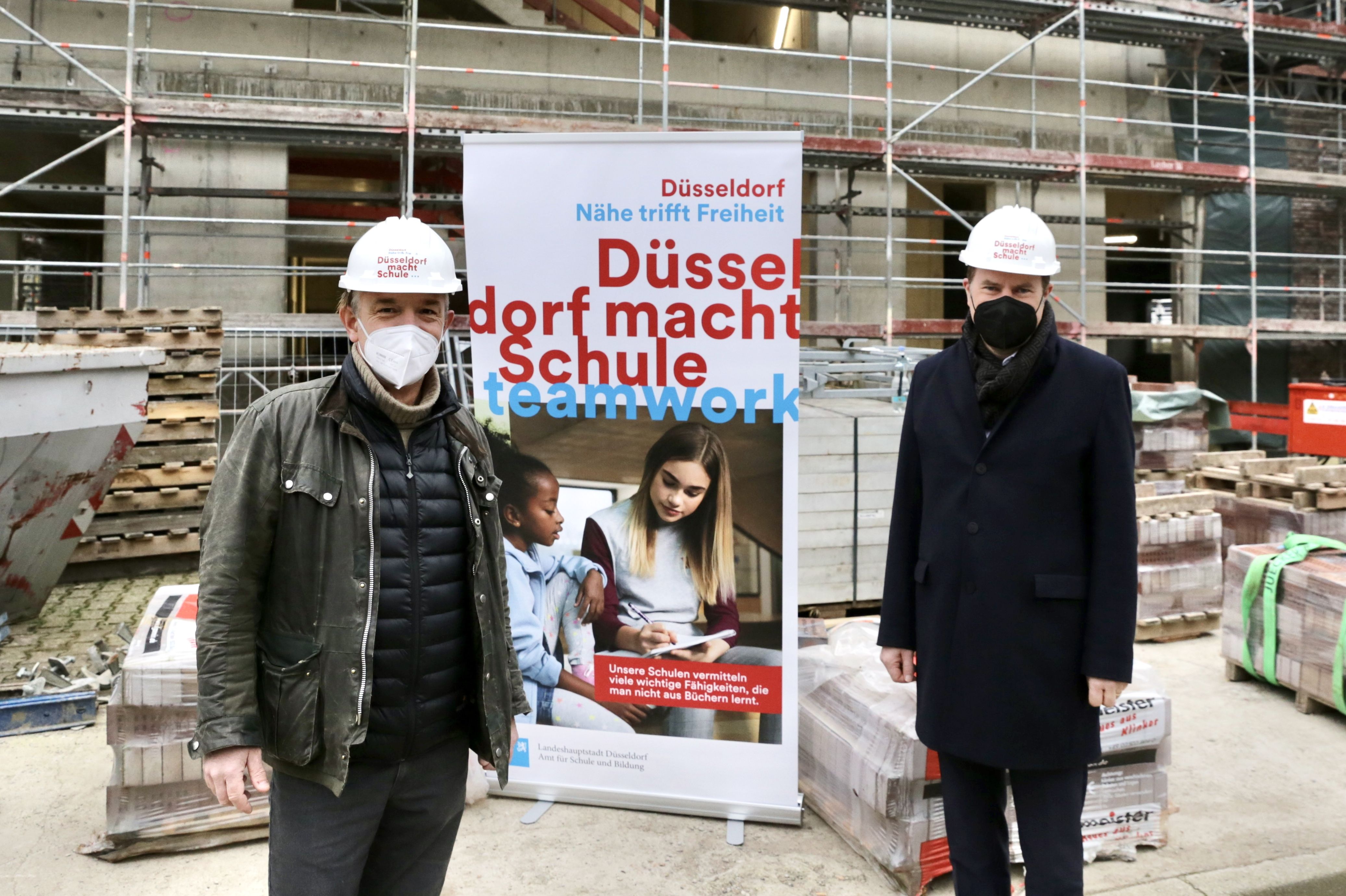 Oberbürgermeister Dr. Stephan Keller (r.) und dem stellvertretenden Schulleiter Hans-Jürgen Stork am Rohbau des neuen Schulgebäudes mit Wettkampfsporthalle © Landeshauptstadt Düsseldorf/Ingo Lammert 