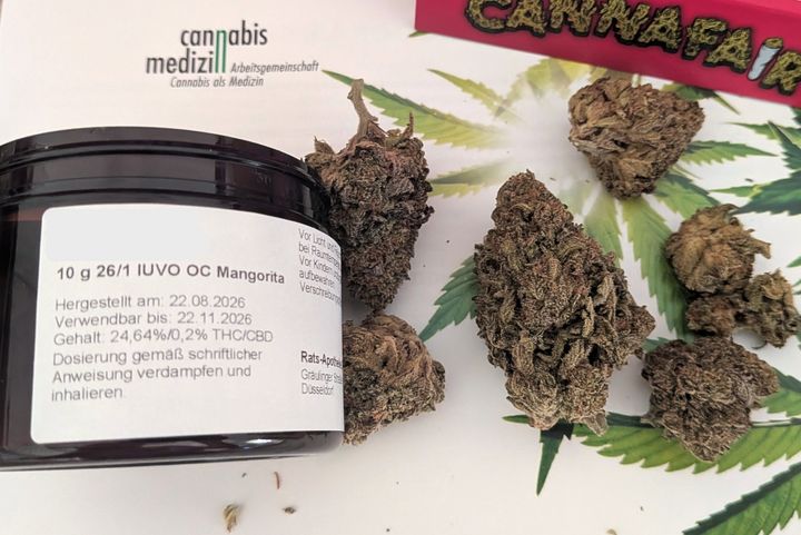 Medizinalcannabis aus der Rats-Apotheke auf der Cannafair Eine beschriftete schwarze Apothekendose steht neben medizinischen Cannabisblüten auf Informationsmaterial der Cannafair Düsseldorf.