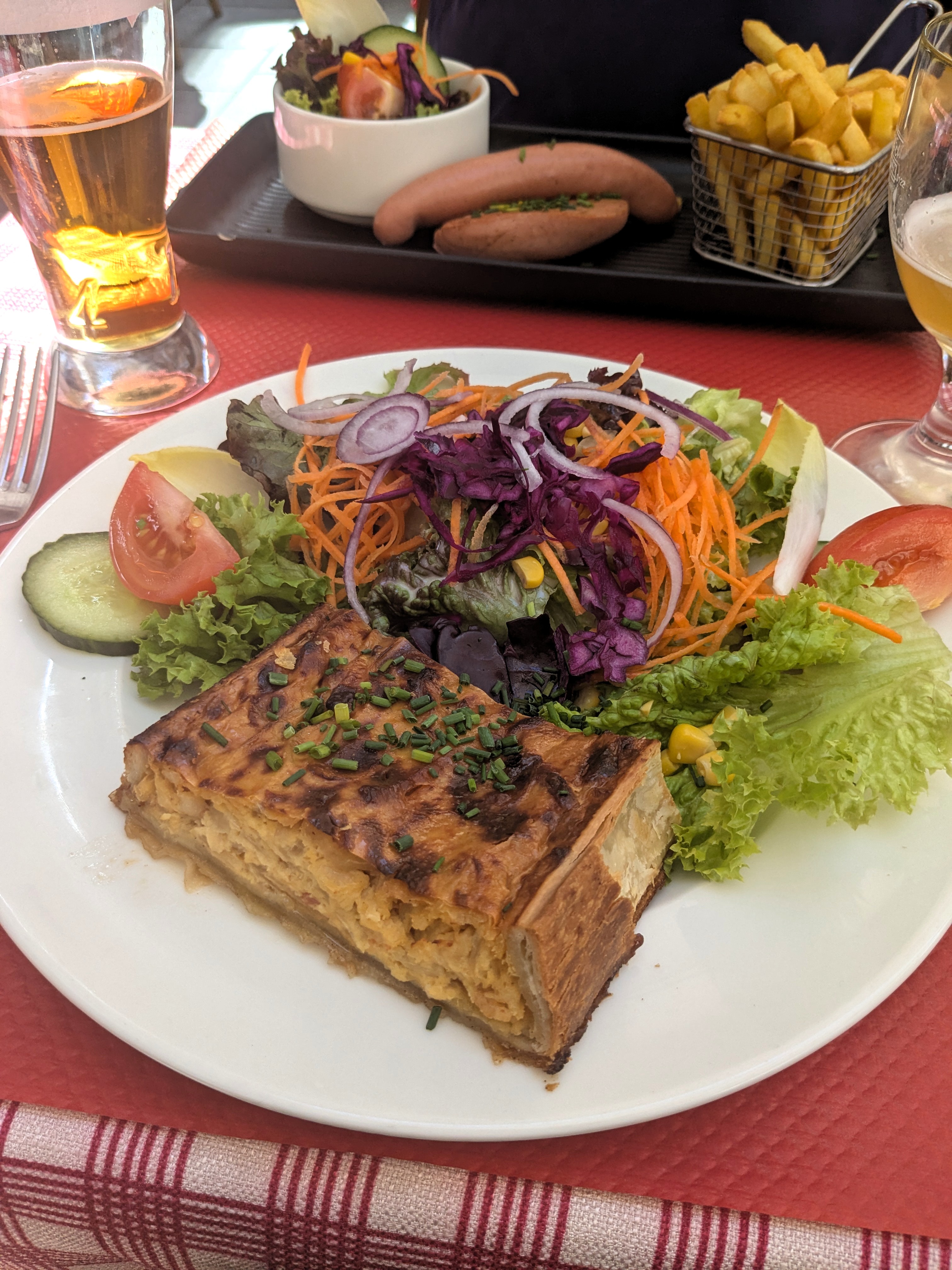 Tarte aux oignons mit Salat auf einem Teller in der Brasserie Au Gutenberg in Straßburg.