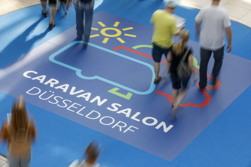 Menschen, welche auf einem Boden mit dem CARAVON SALON DÜSSELDORF Logo laufen