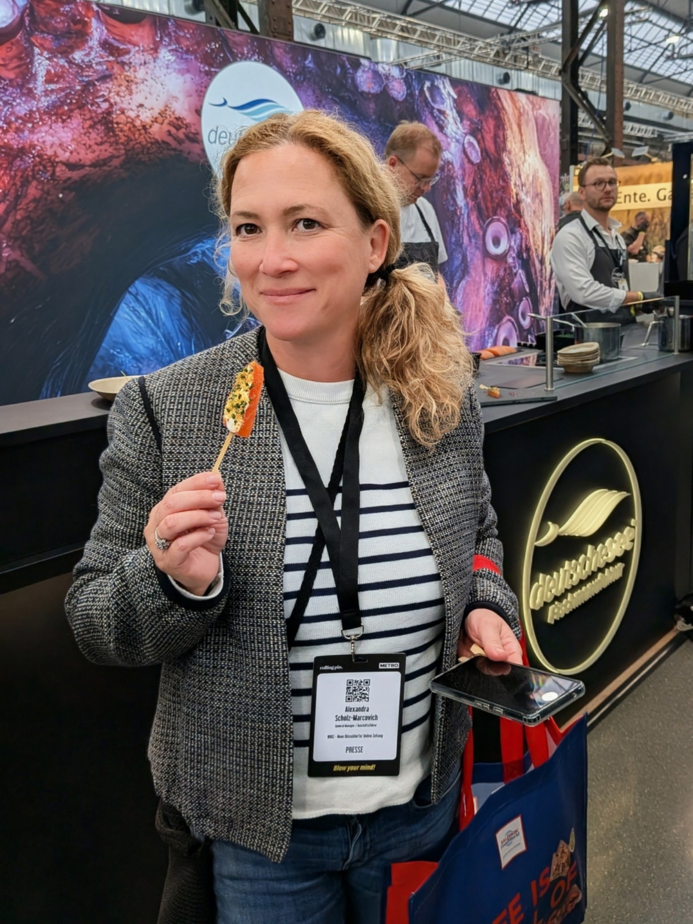 Alex mit Fisch-Snack – Kleine Kostprobe am Stand der Deutschen See – die Messehallen als kulinarisches Abenteuer. / Foto: NDOZ