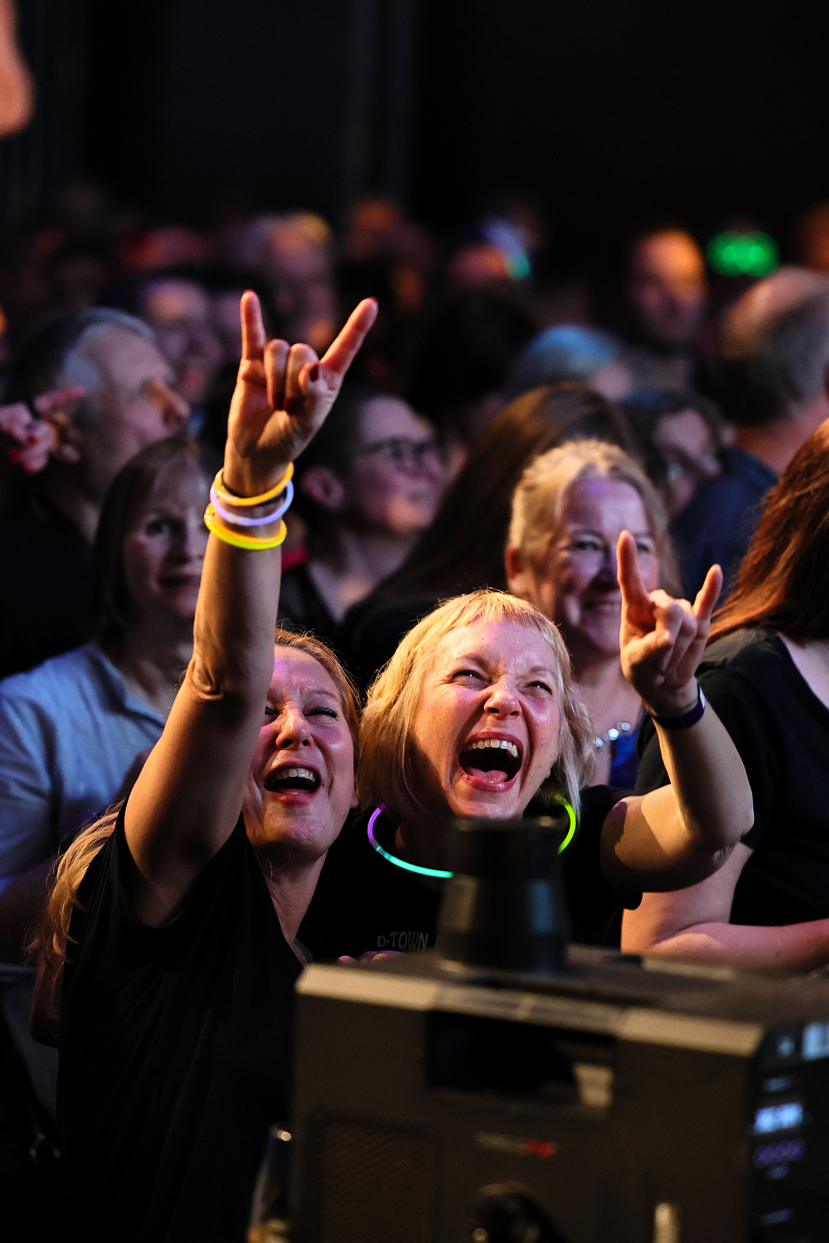 Jubelnde Menschen mit erhobenen Händen direkt an der Bühnenkante.