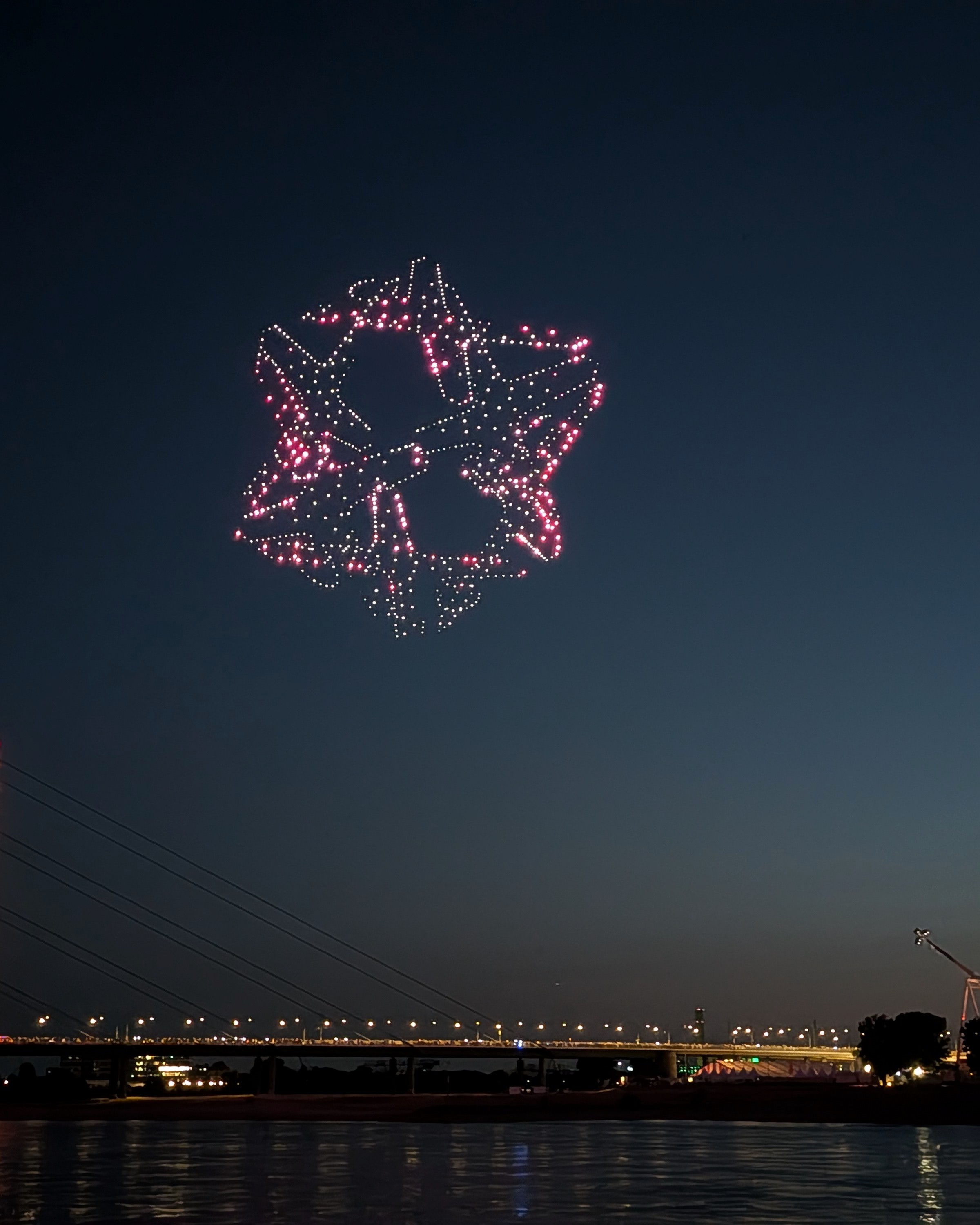 Von Drohnen geformter Düsseldorfer Radschläger über der Rheinkniebrücke und der Rheinkirmes