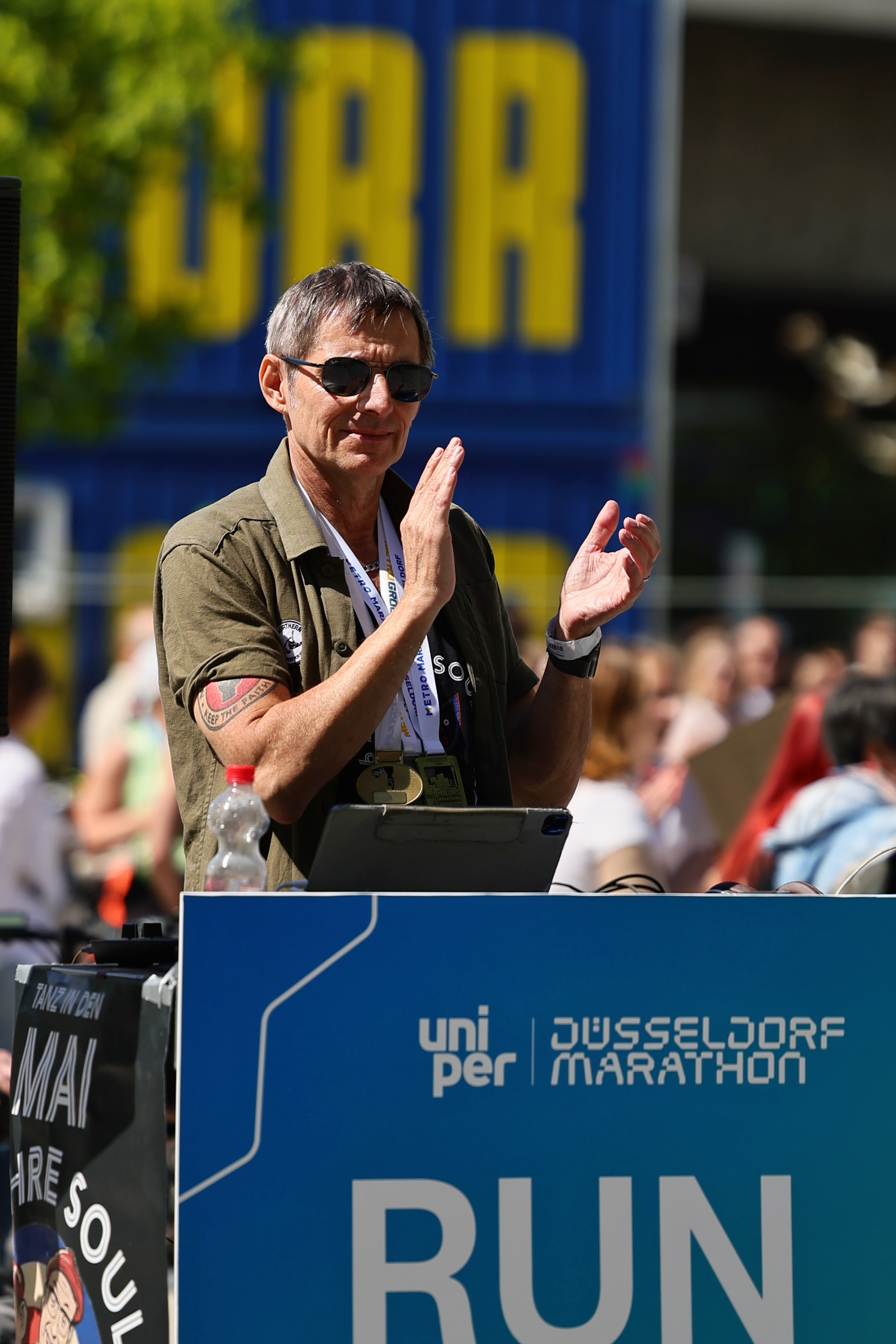 Moderator klatscht auf der Bühne beim Uniper Düsseldorf Marathon 2026 vor dem Run-to-the-Beat-Aufbau