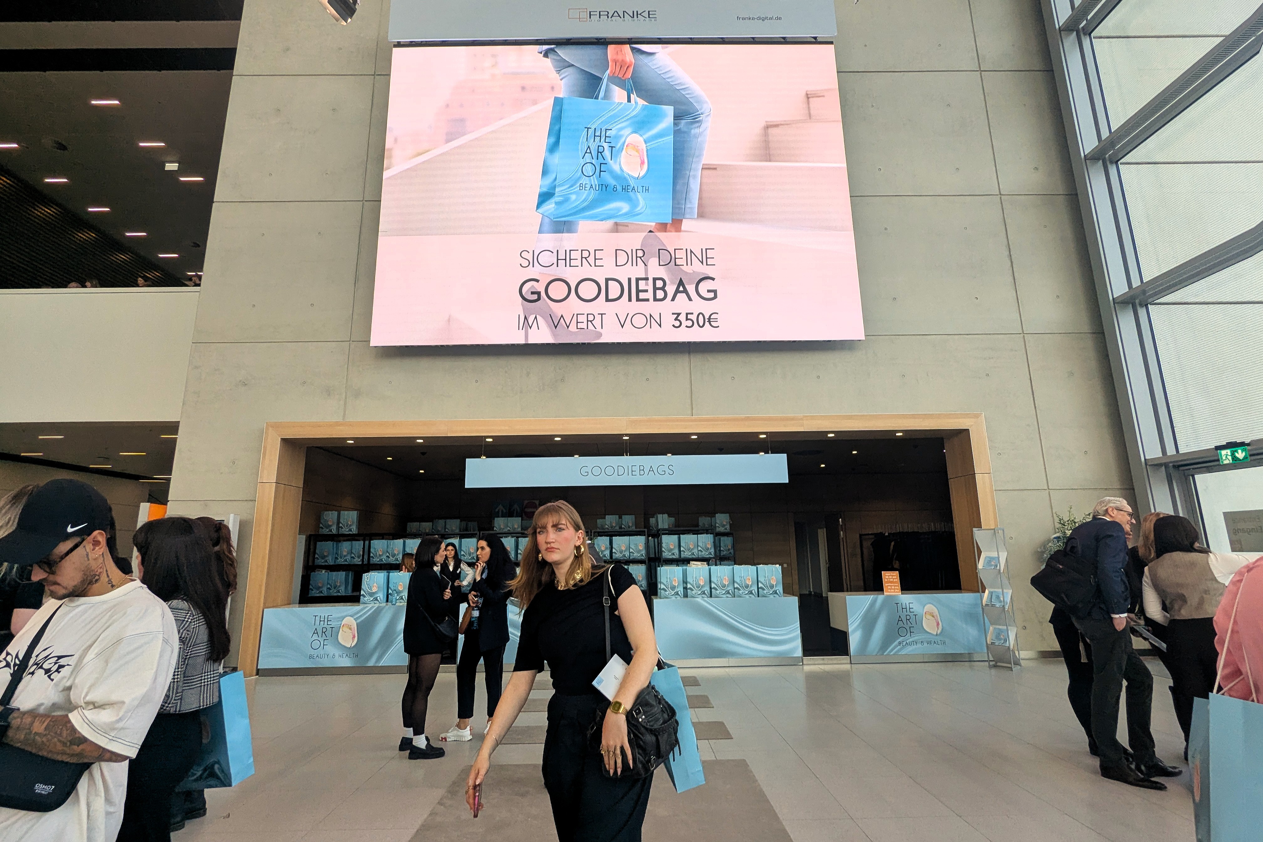 Besucherin vor dem Goodiebag-Stand der Art of Beauty & Health, Messe Düsseldorf, März 2026