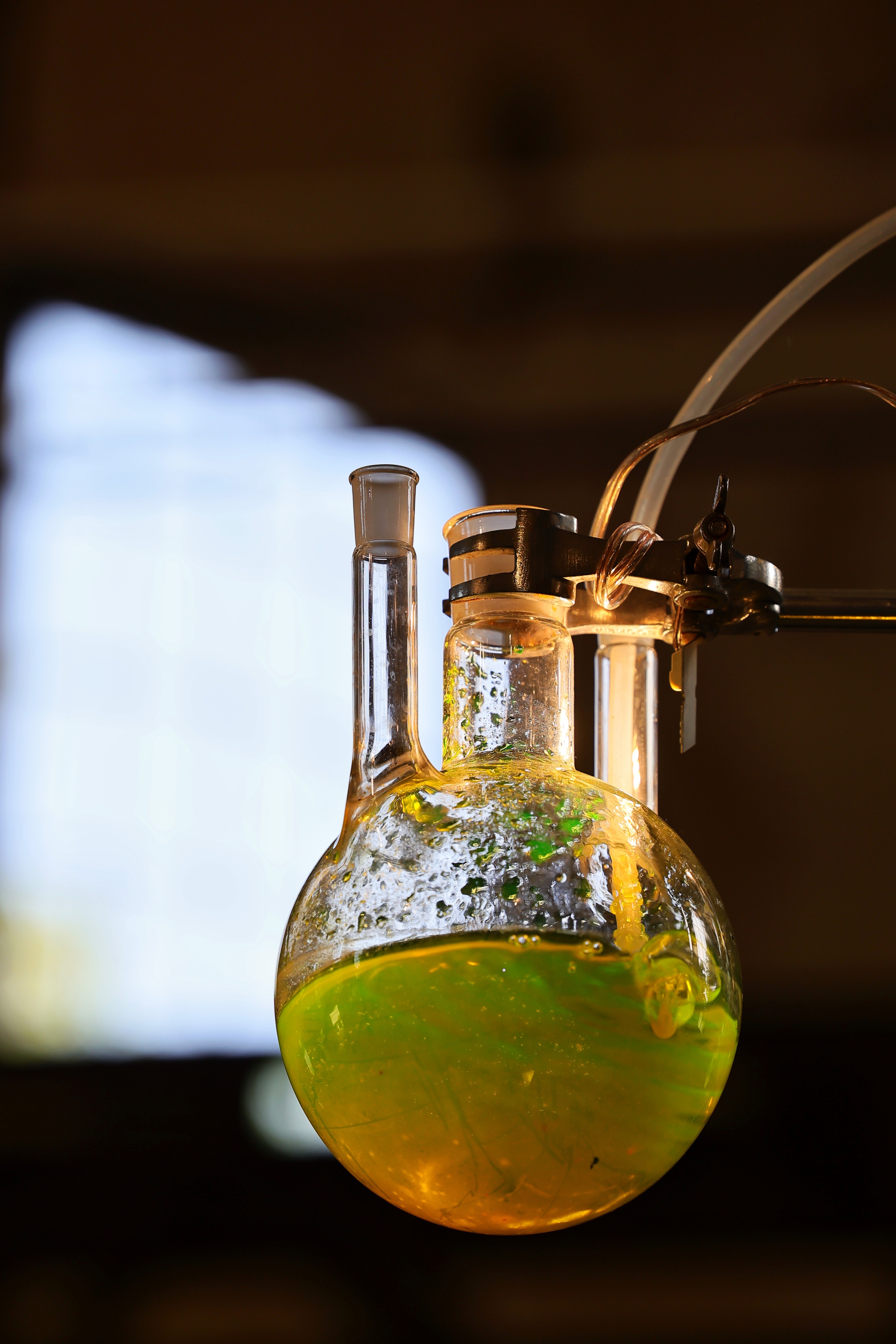 Glasbehälter mit gelblicher Flüssigkeit und mechanischen Elementen in der Ausstellung „Von Höhen und Tiefen“ im historischen Klärwerk Uerdingen.